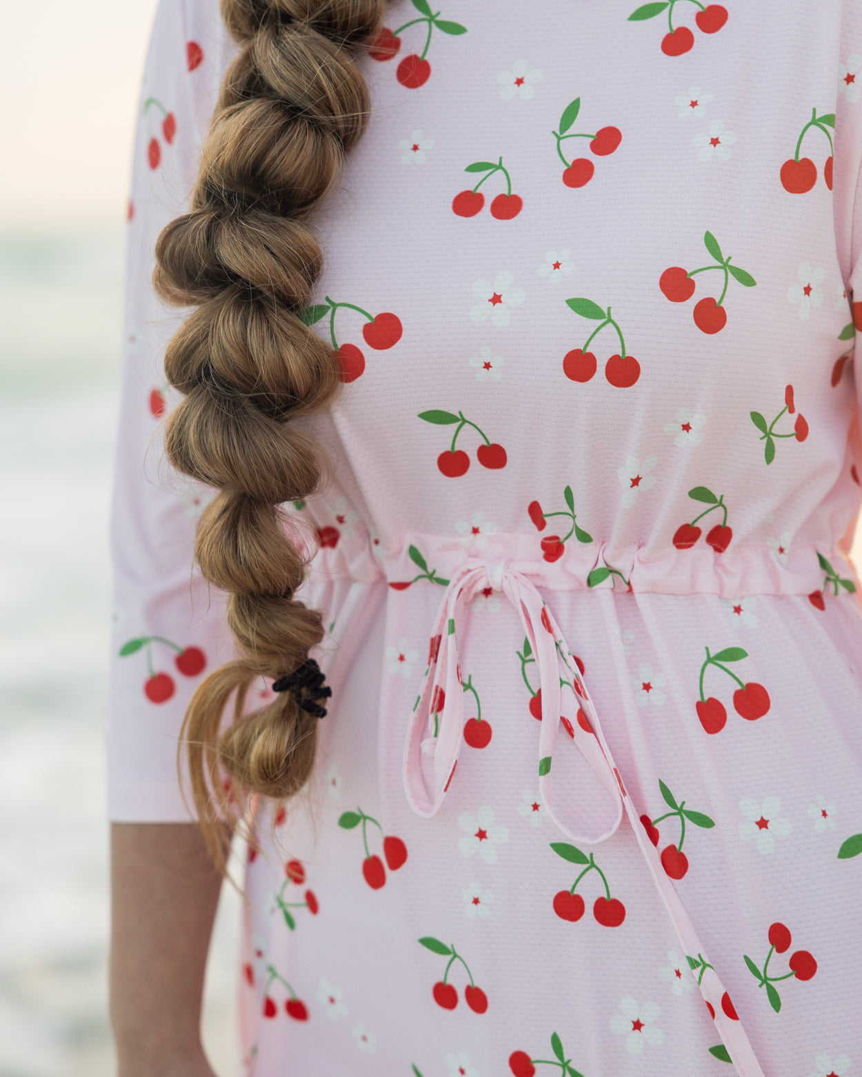 Model wearing Nuggles® Nola Sport Swim Dress in Cherry Soda Shop