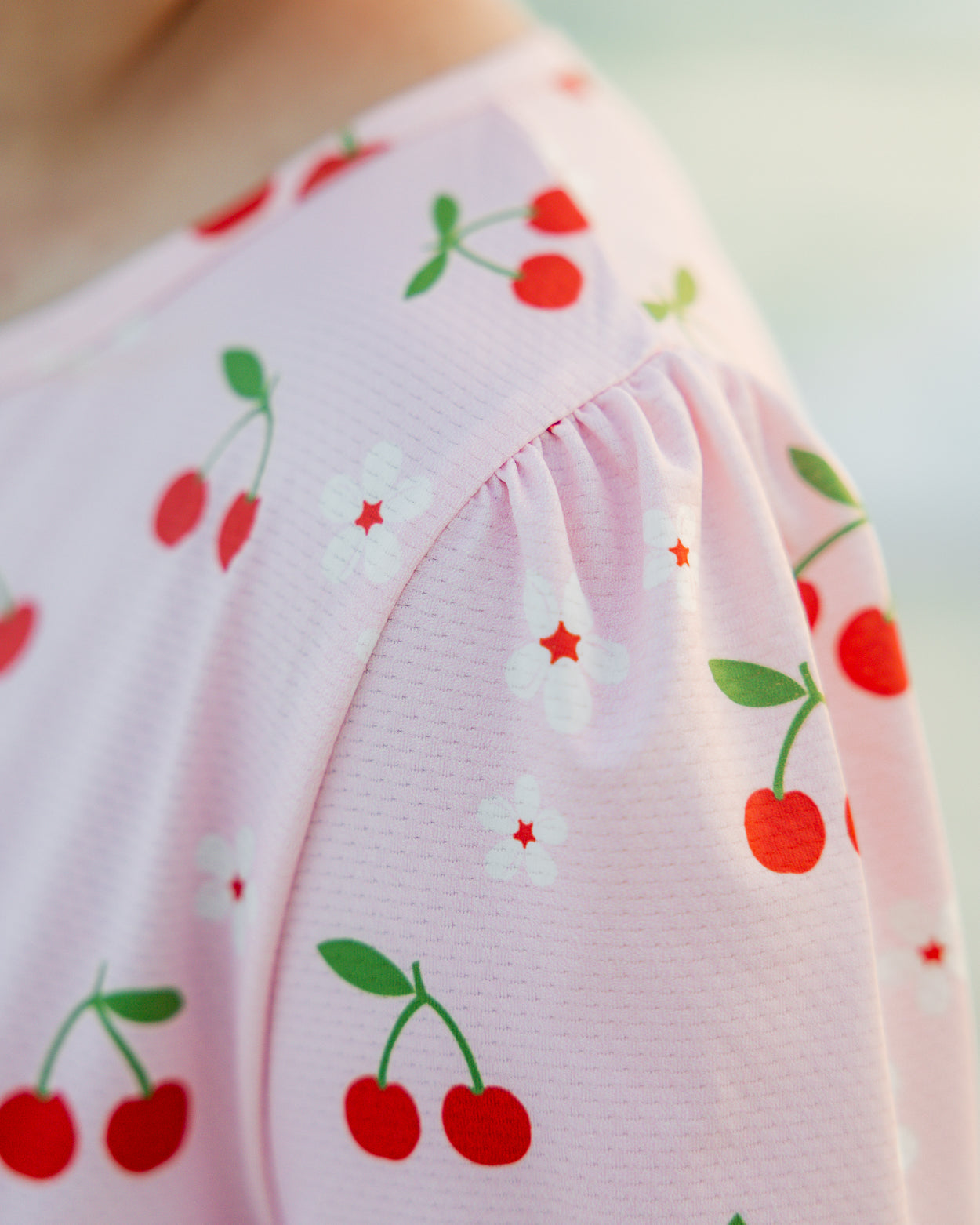 Model wearing Nuggles® Nola Sport Swim Dress in Cherry Soda Shop