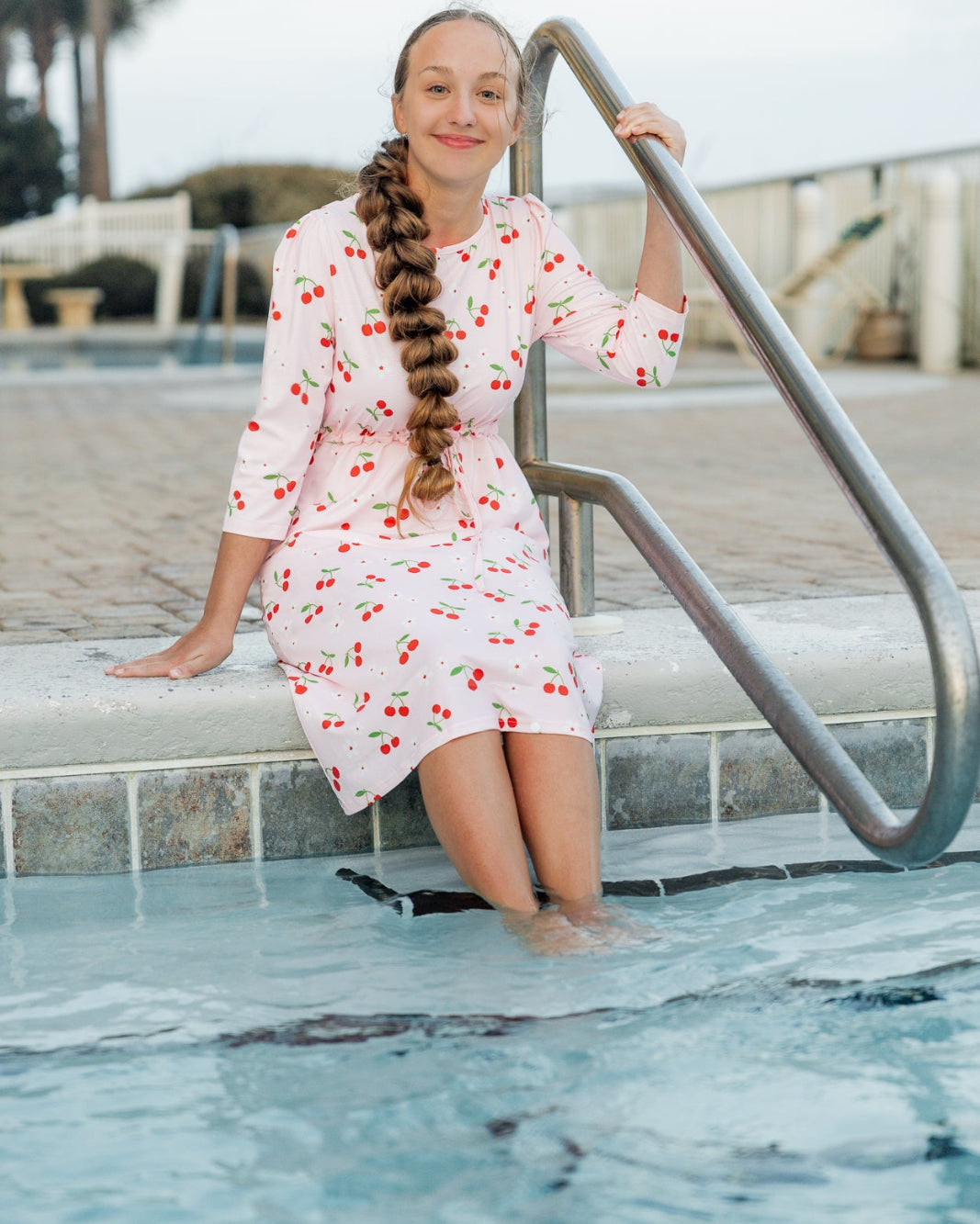 Model wearing Nuggles® Nola Sport Swim Dress in Cherry Soda Shop