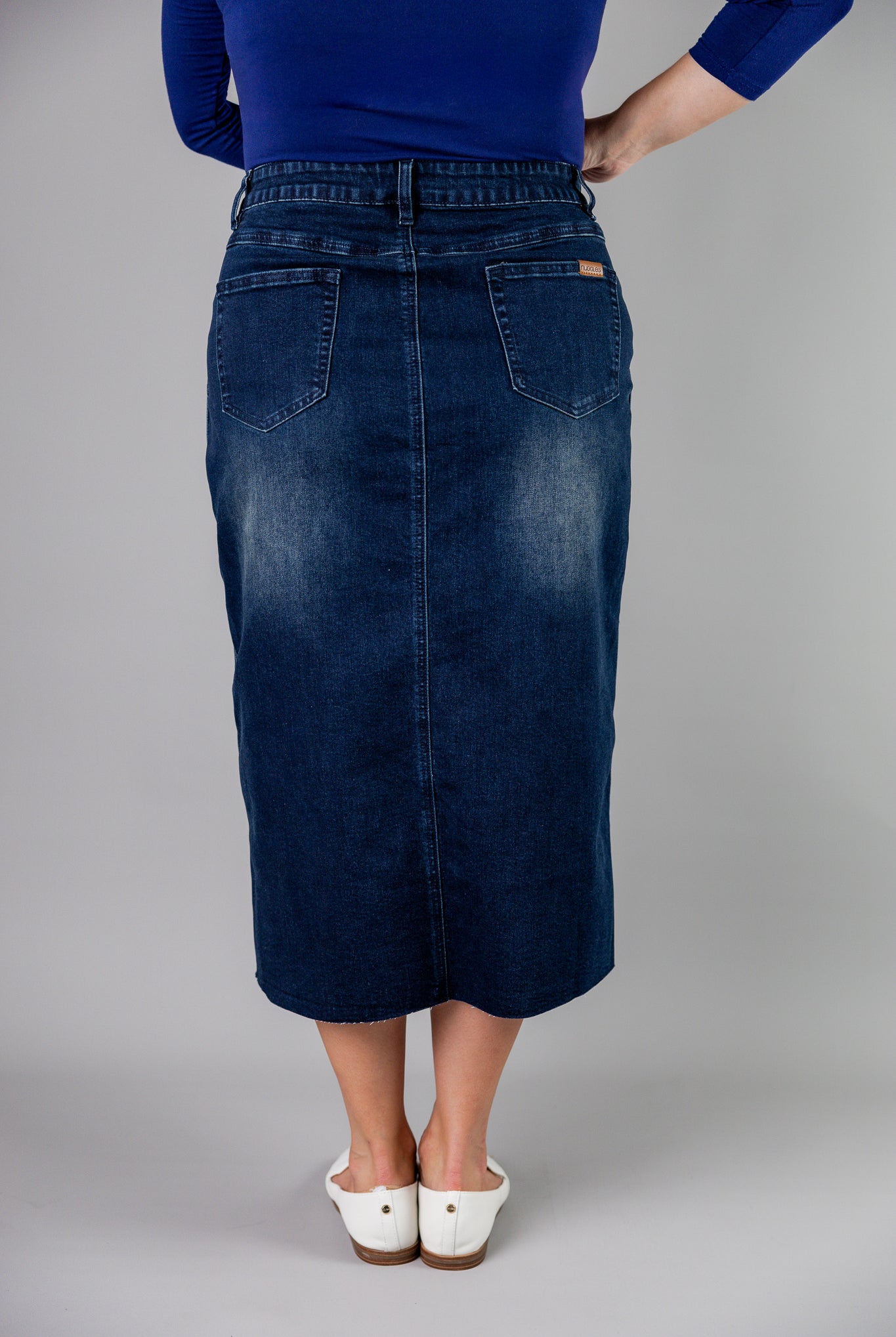 Nuggles® denim midi skirt with soft stretch fabric, wide elastic waistband, modest length, and functional pockets. Available in 27", 31", and 34" lengths.