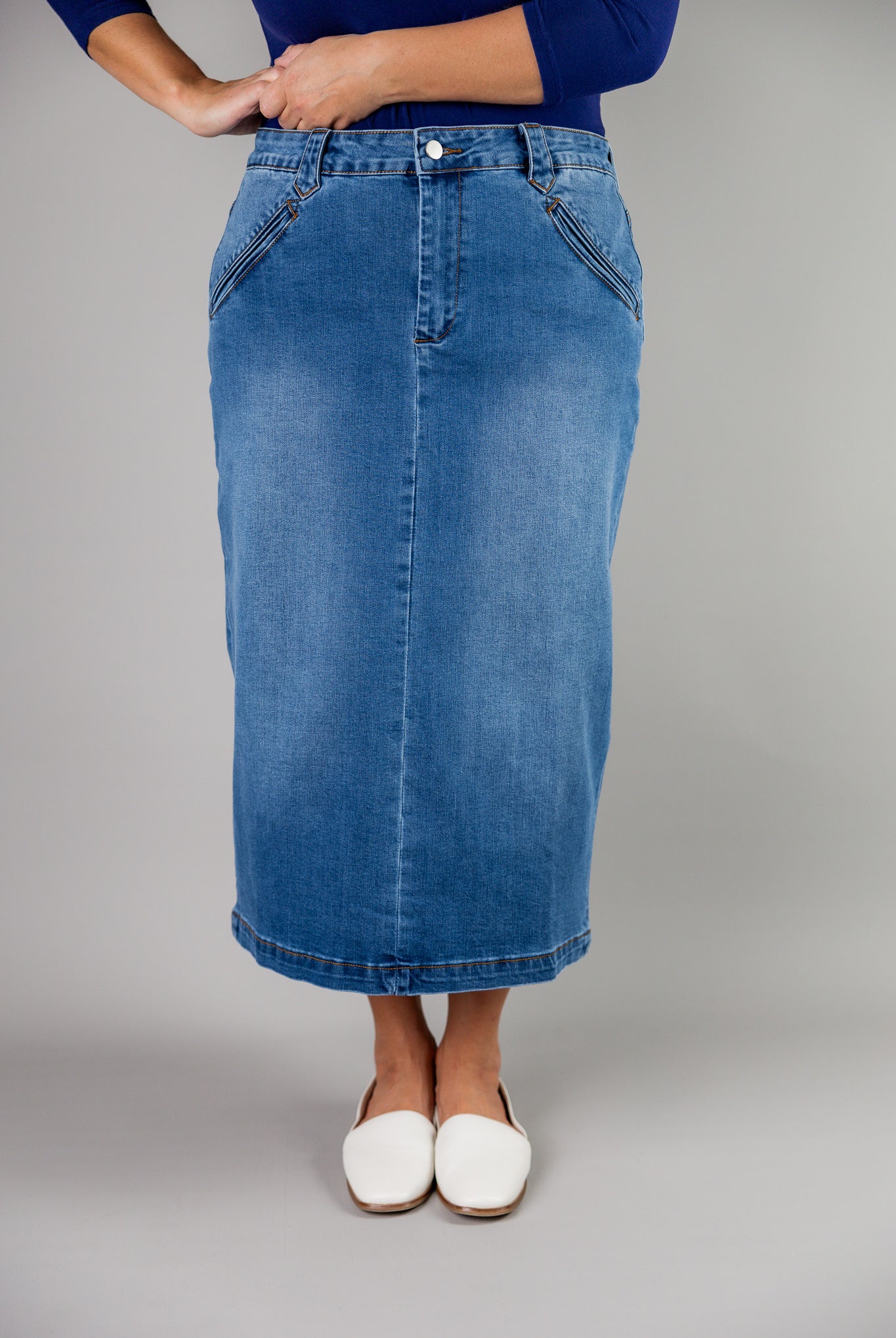 Nuggles® denim midi skirt with soft stretch fabric, wide elastic waistband, modest length, and functional pockets. Available in 27", 31", and 34" lengths.