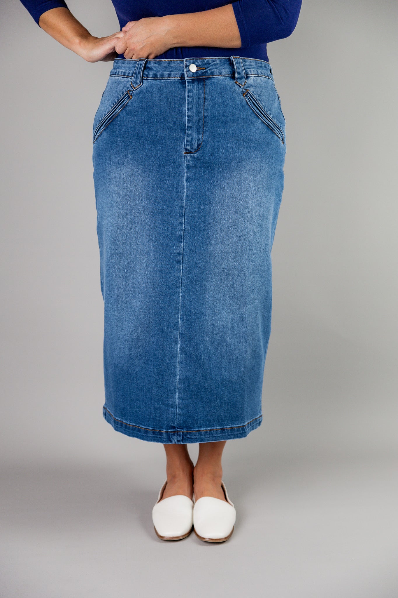 Nuggles® denim midi skirt with soft stretch fabric, wide elastic waistband, modest length, and functional pockets. Available in 27", 31", and 34" lengths.