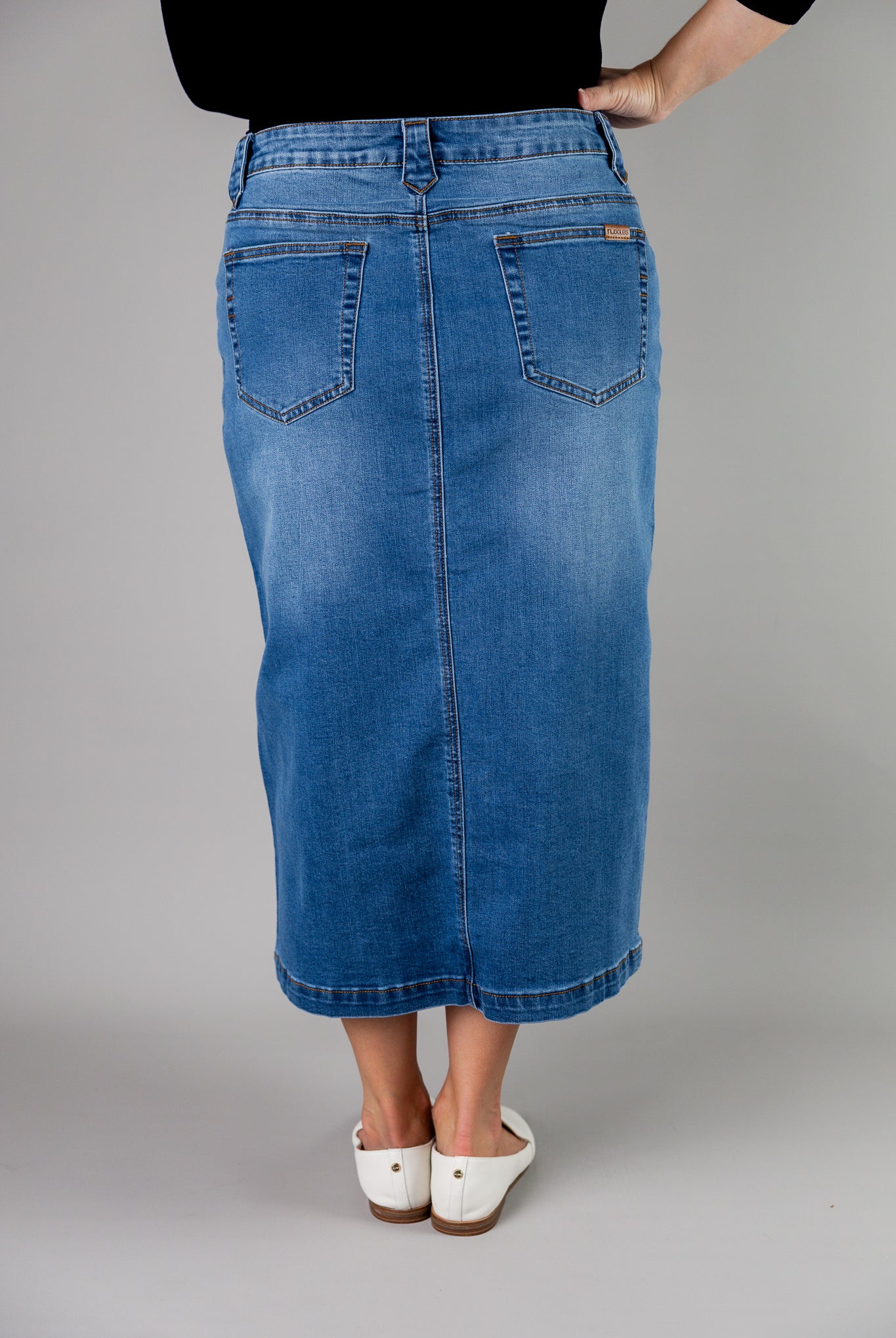 Nuggles® denim midi skirt with soft stretch fabric, wide elastic waistband, modest length, and functional pockets. Available in 27", 31", and 34" lengths.