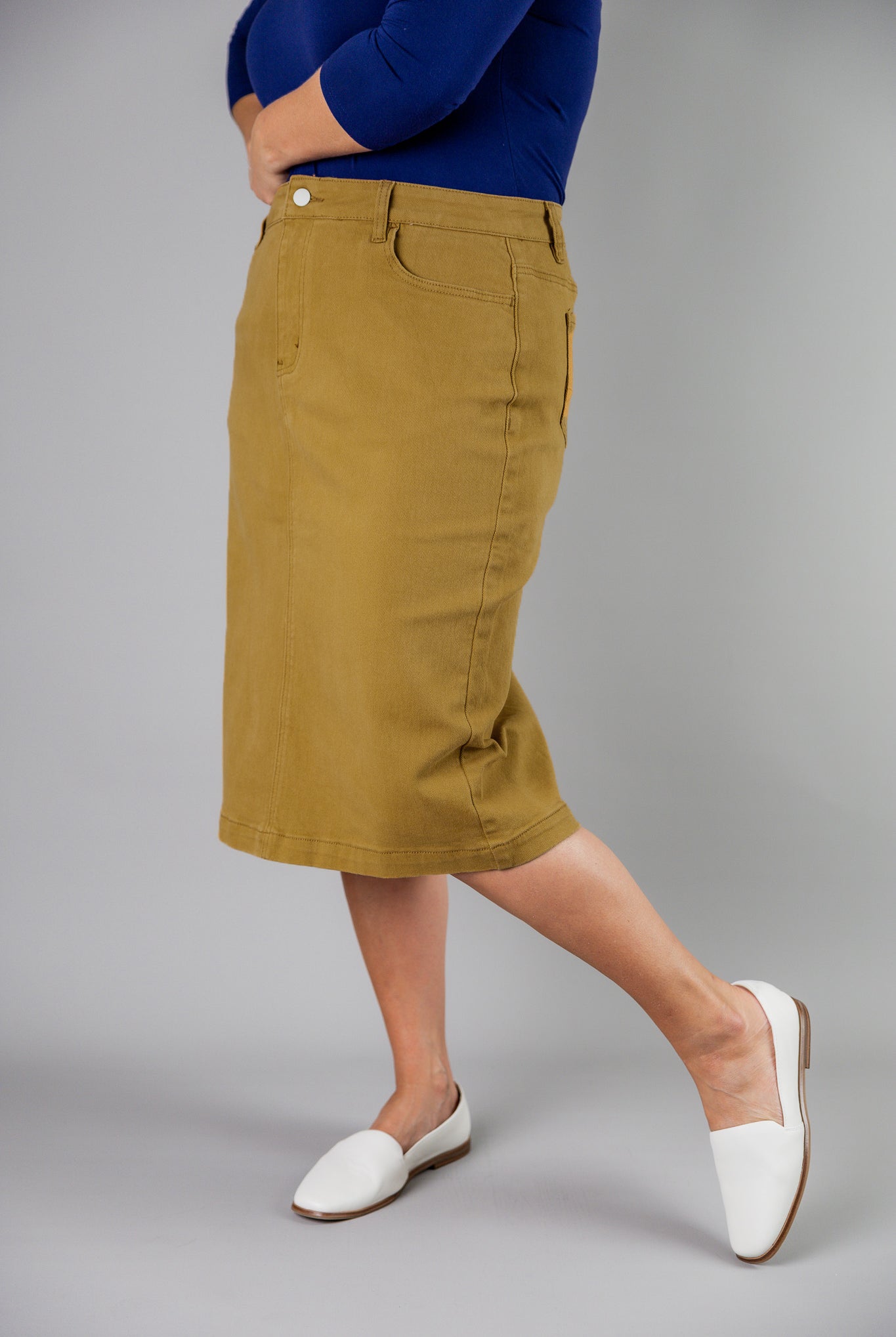 Nuggles® denim midi skirt with soft stretch fabric, wide elastic waistband, modest length, and functional pockets. Available in 27", 31", and 34" lengths.