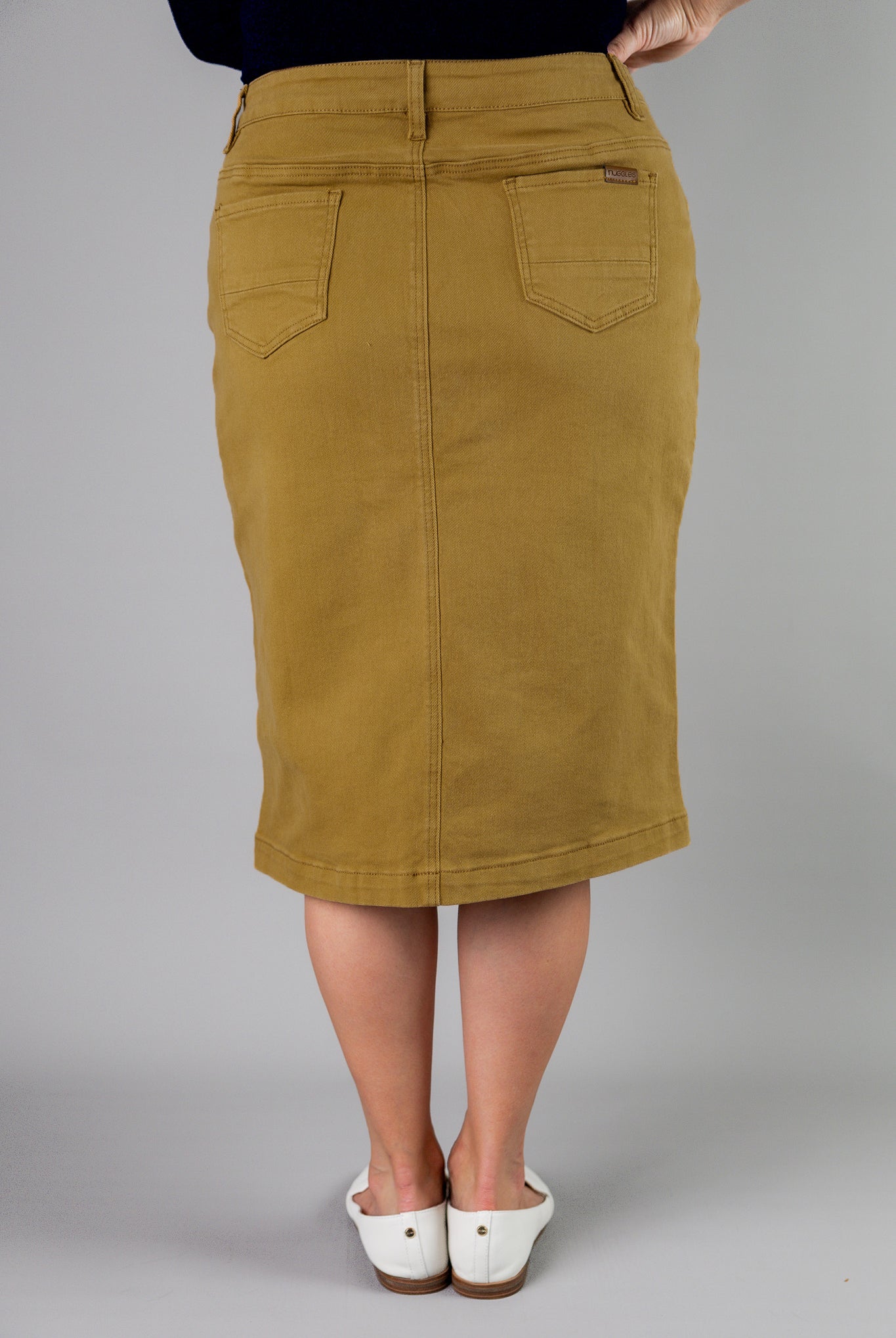 Nuggles® denim midi skirt with soft stretch fabric, wide elastic waistband, modest length, and functional pockets. Available in 27", 31", and 34" lengths.