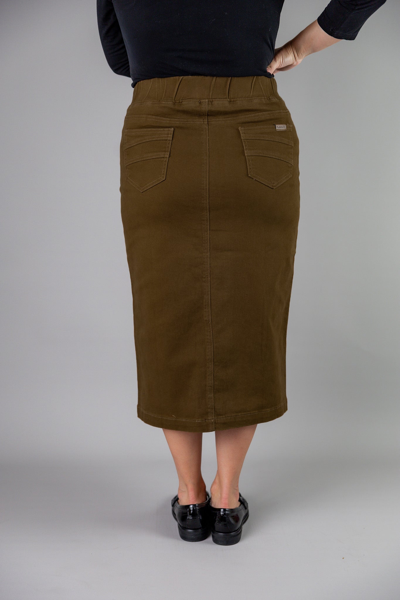 Nuggles® denim midi skirt with soft stretch fabric, wide elastic waistband, modest length, and functional pockets. Available in 27", 31", and 34" lengths.