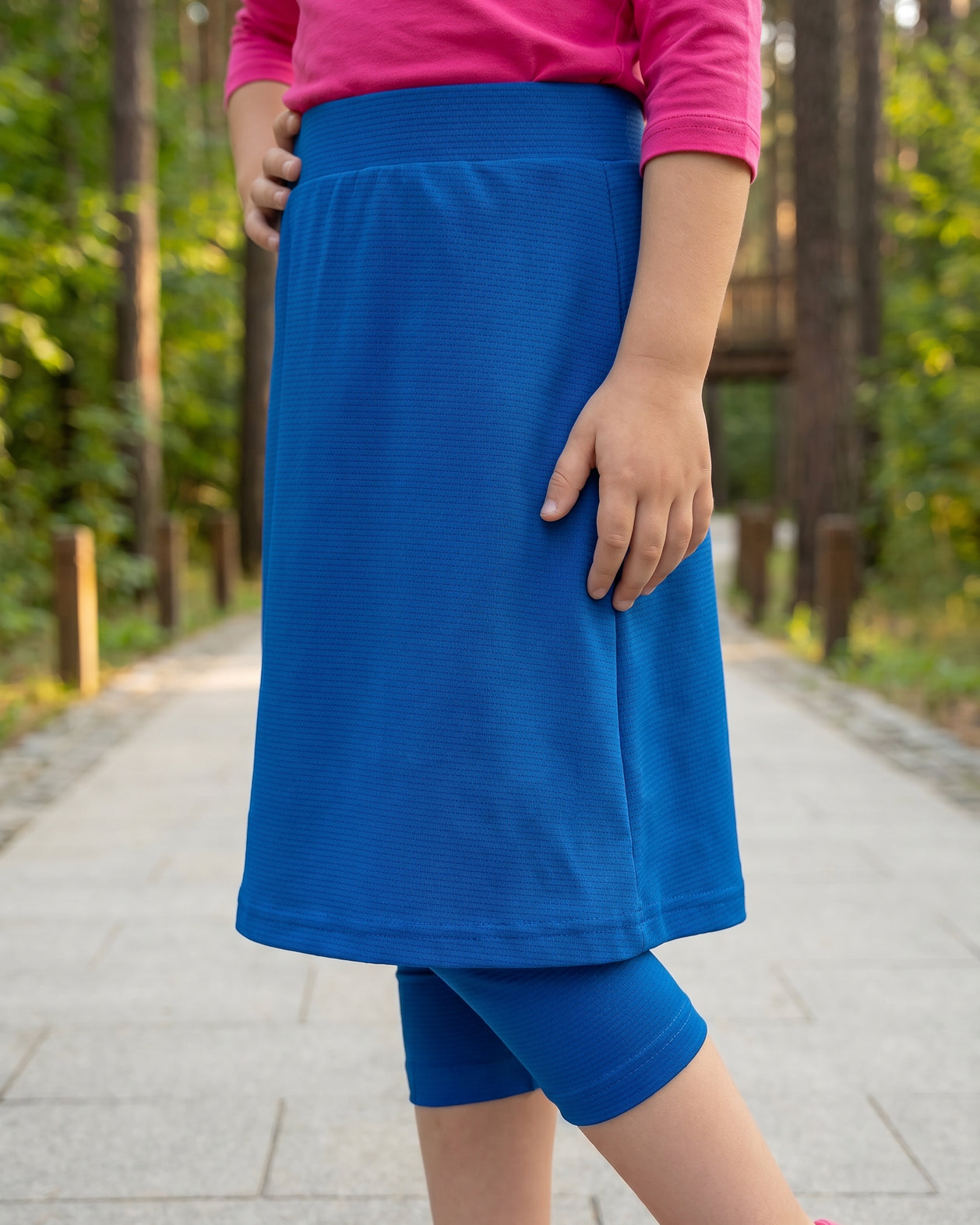 Model wearing Nuggles® Girls All-Sport Skirt in Lapiz Blue