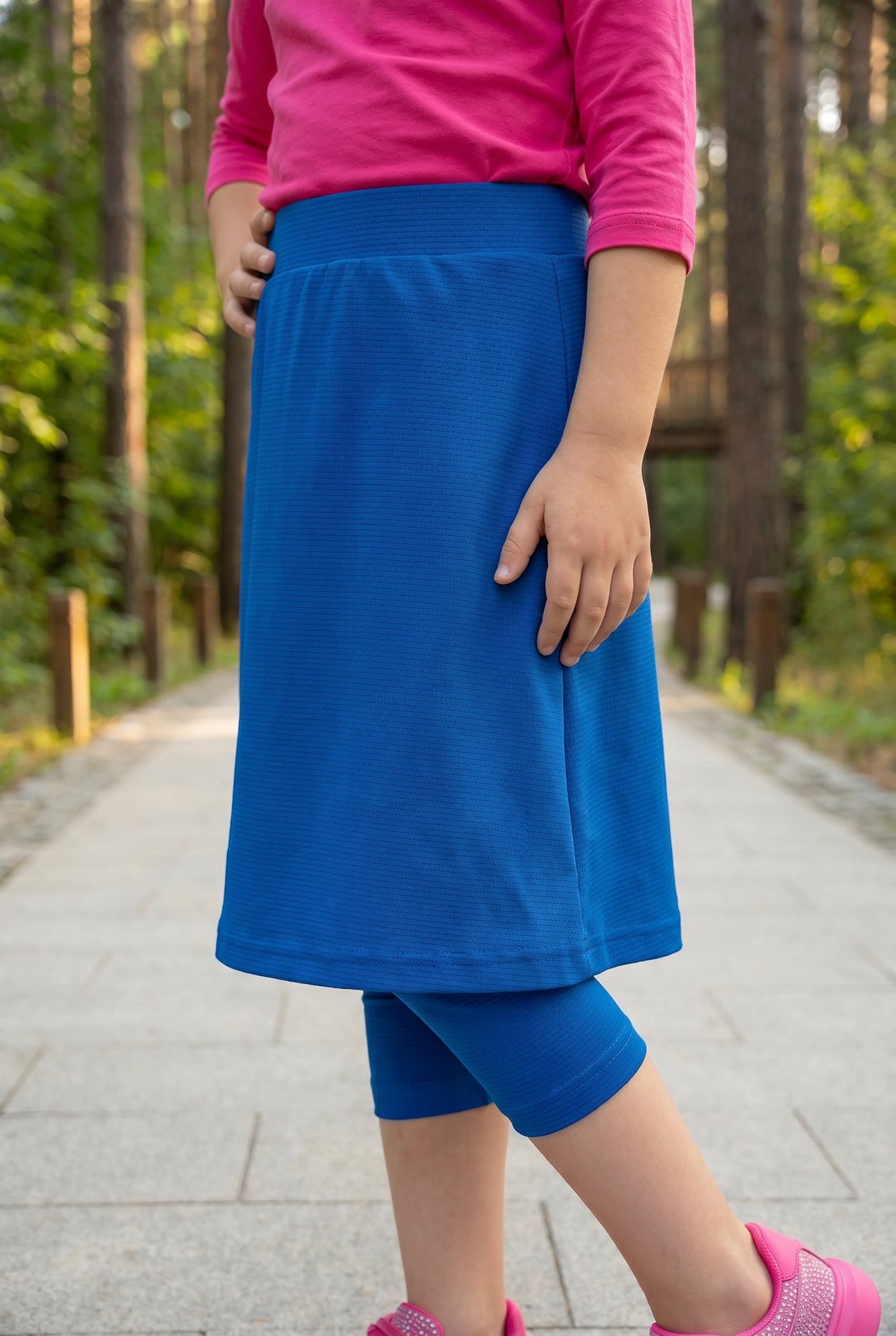 Model wearing Nuggles® Girls All-Sport Skirt in Lapiz Blue