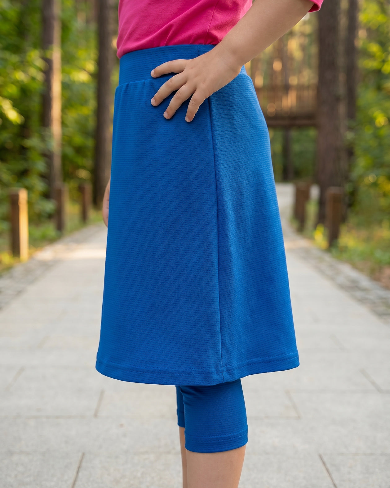 Model wearing Nuggles® Girls All-Sport Skirt in Lapiz Blue
