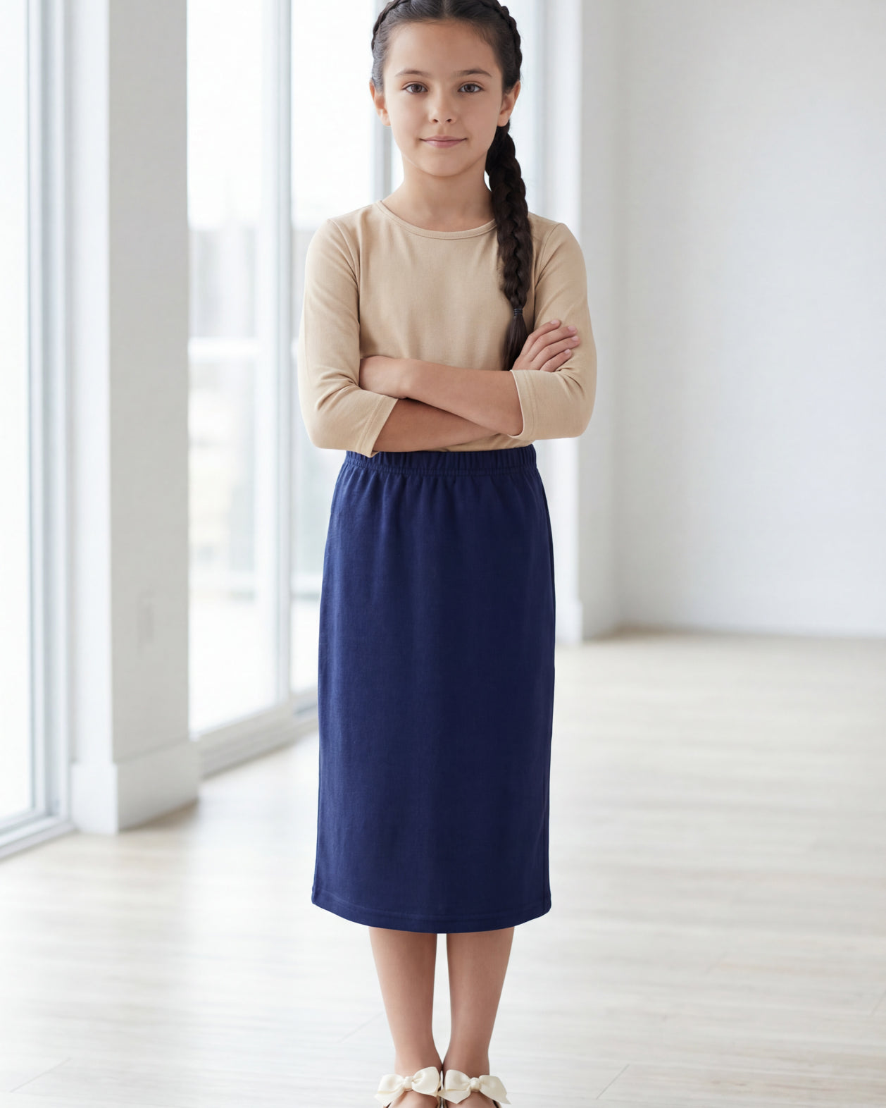 Model wearing the Nuggles® Girls' Classic Midi Skirt in Navy