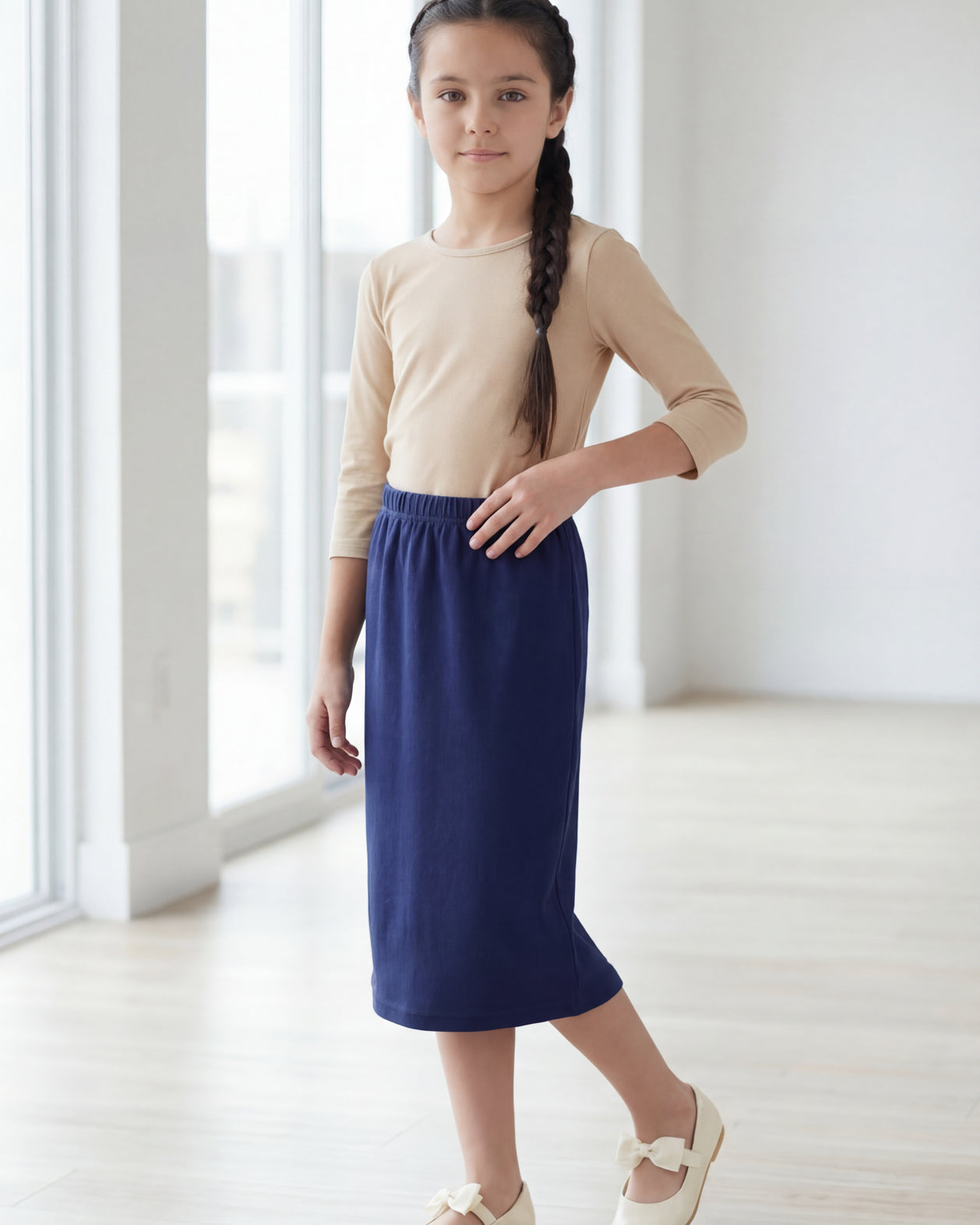 Model wearing the Nuggles® Girls' Classic Midi Skirt in Navy