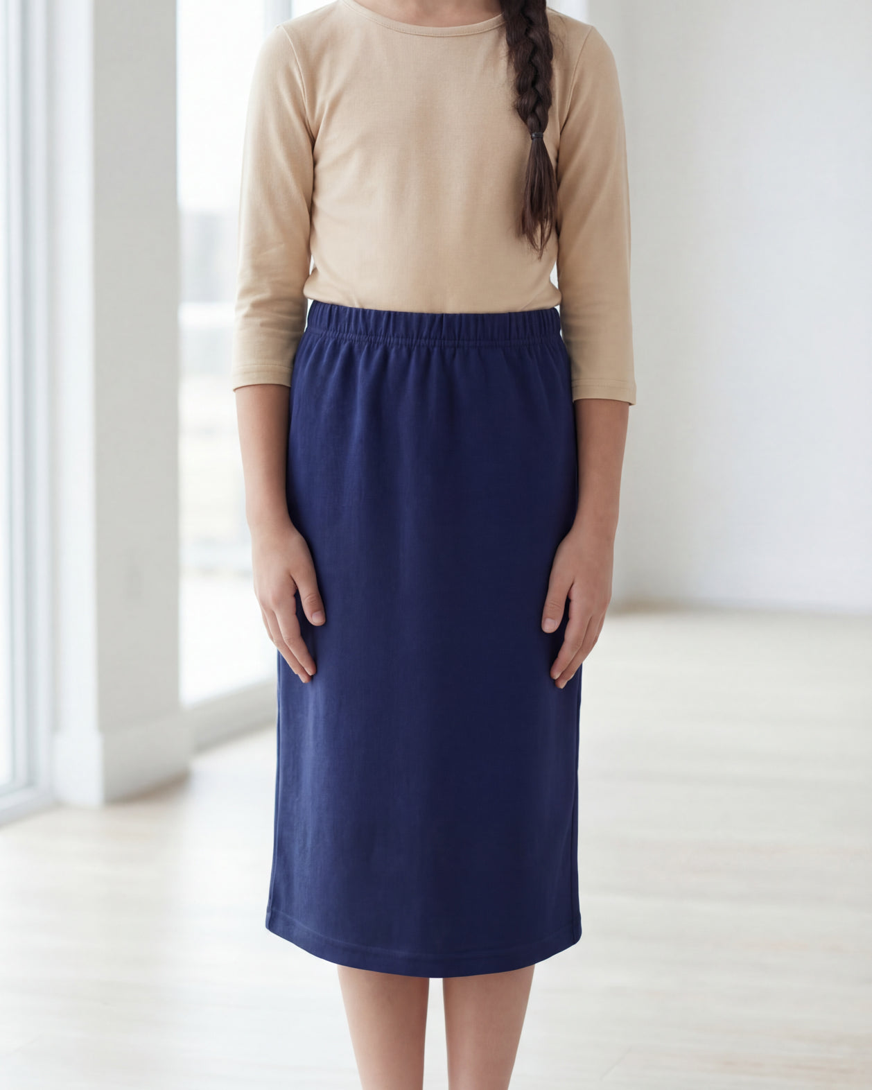 Model wearing the Nuggles® Girls' Classic Midi Skirt in Navy