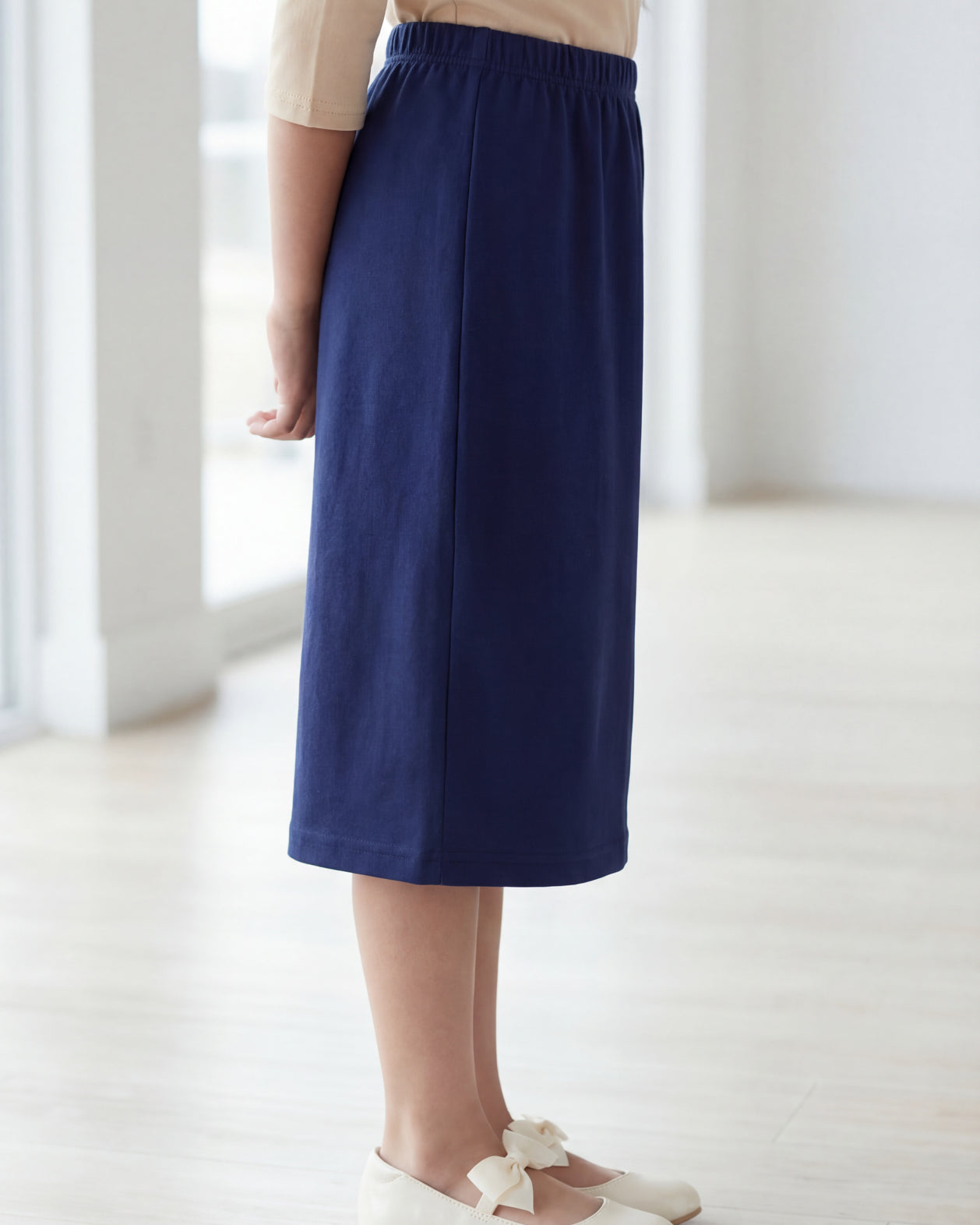 Model wearing the Nuggles® Girls' Classic Midi Skirt in Navy
