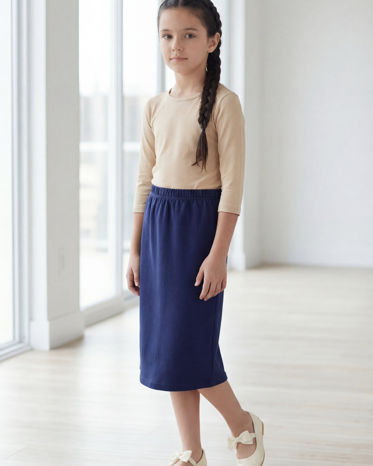 Model wearing the Nuggles® Girls' Classic Midi Skirt in Navy