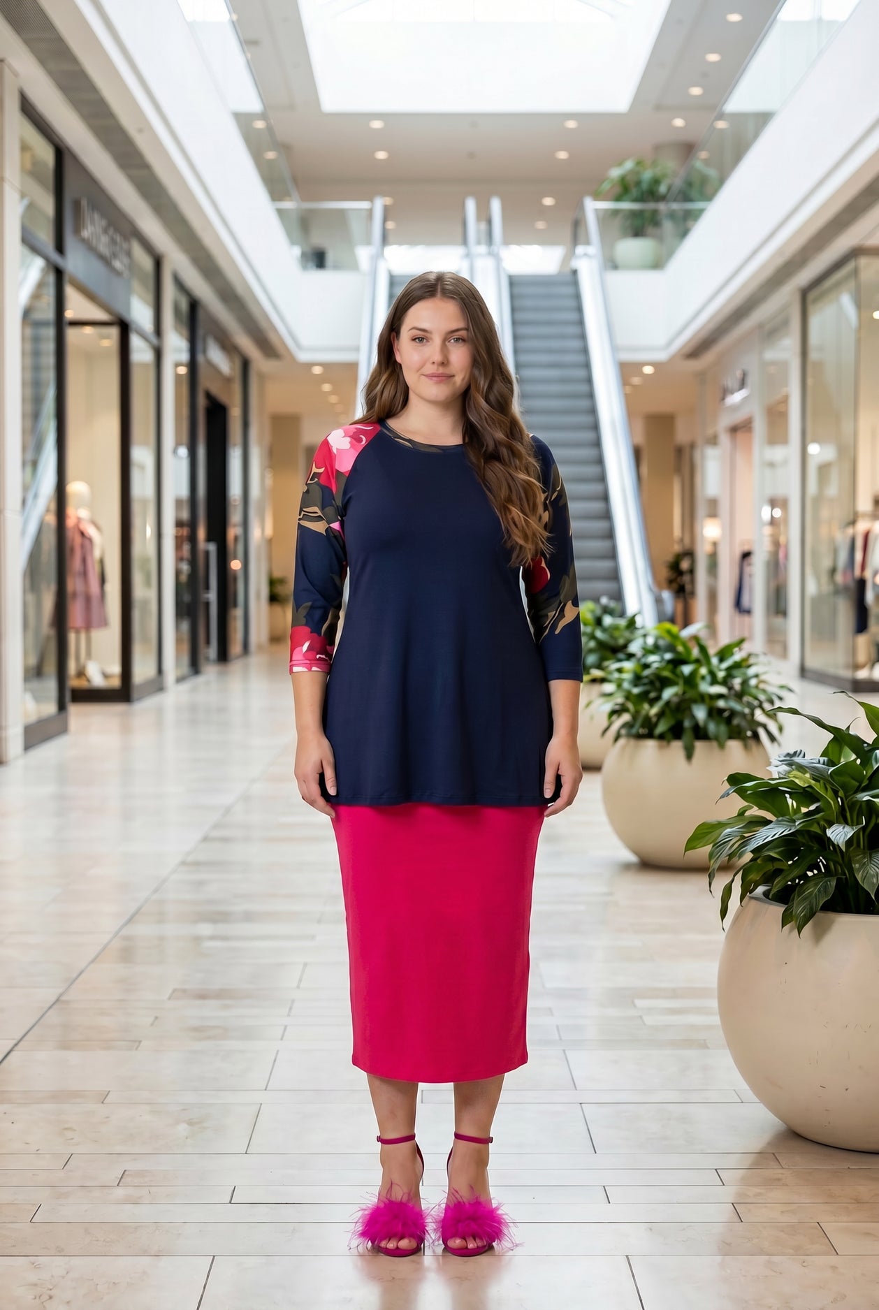 Woman modeling a navy floral-sleeve top in a mall.
