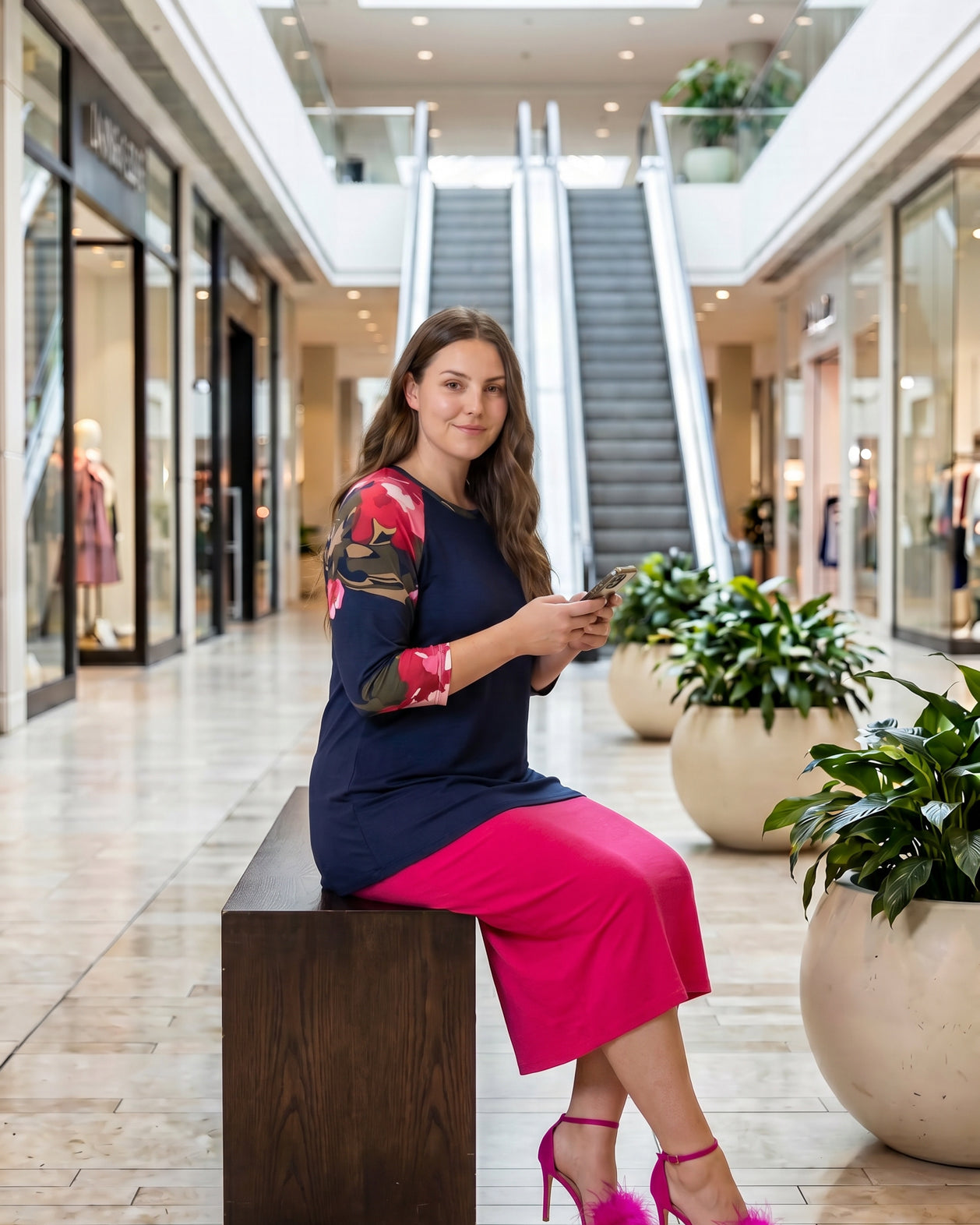 Woman modeling a navy floral-sleeve top in a mall.