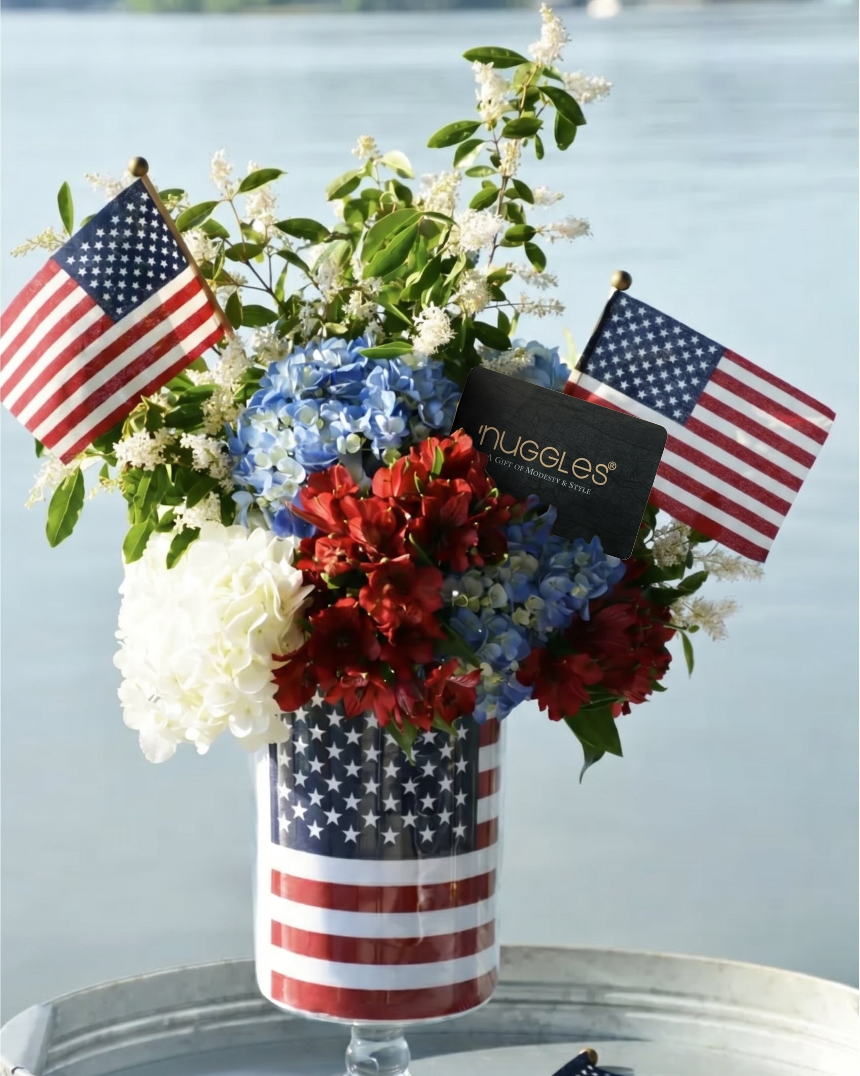 A picture of red, white, and blue flowers with American Flags and a Nuggles Gift Card.