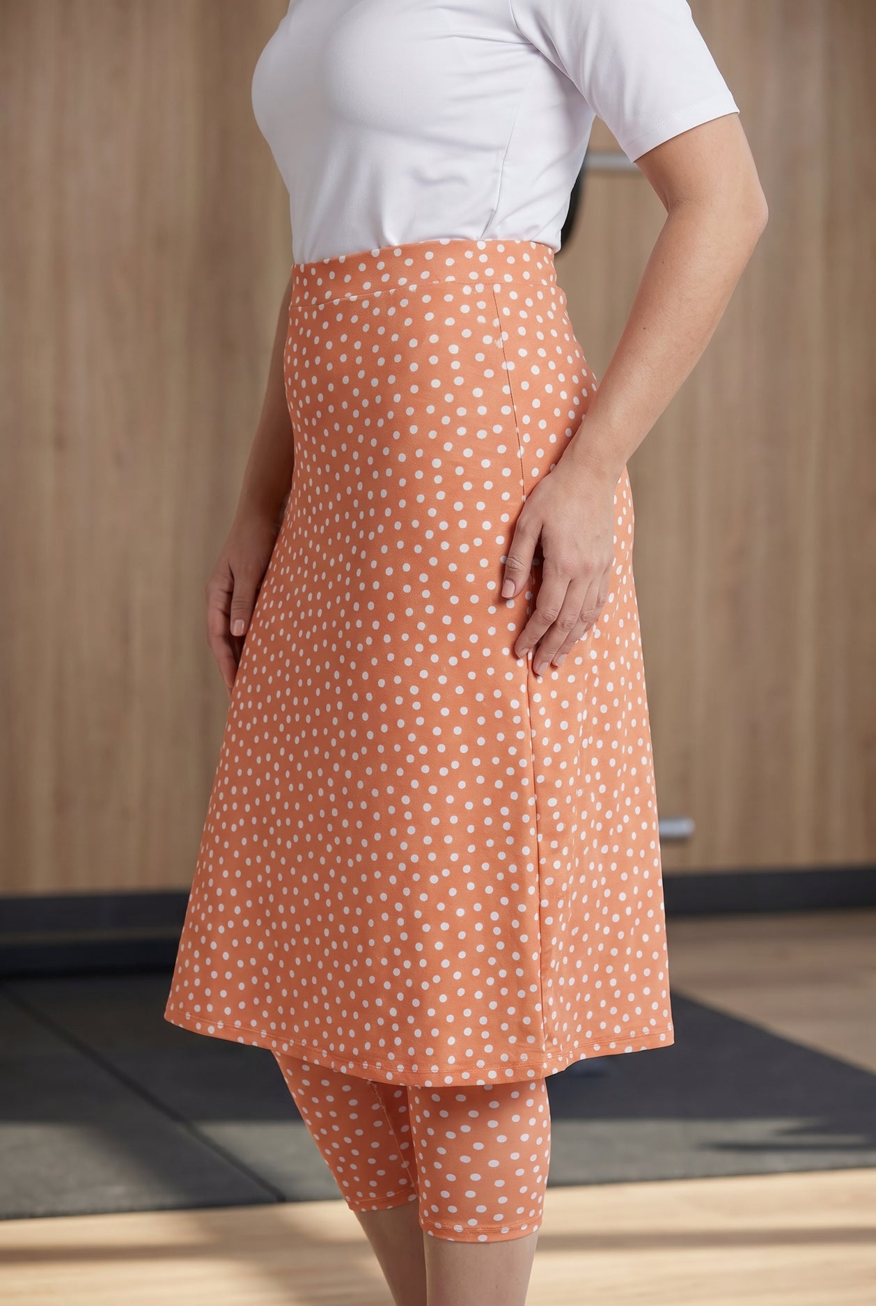 Model wearing Nuggles® 27" All-Sport Skirt in Orange Pop