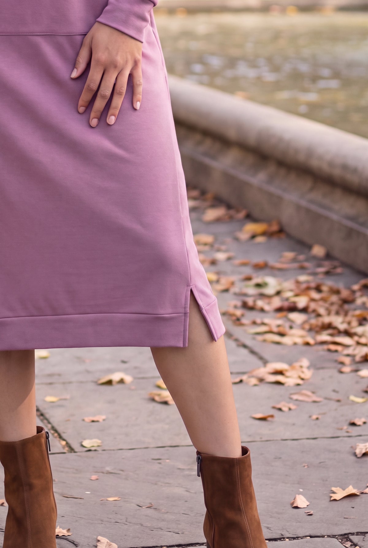 Nuggles® Oakley Hoodie Dress in Pale Purple, close-up of the banded hem and side slit with brown ankle boots