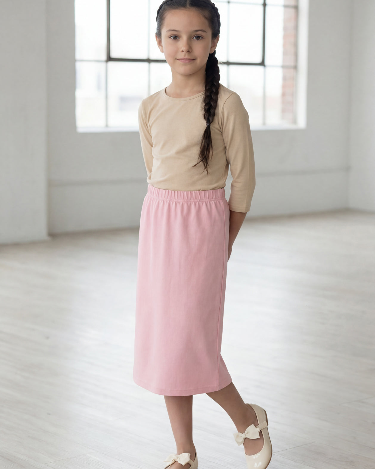 Model wearing the Nuggles® Girls' Classic Midi Skirt in Rose