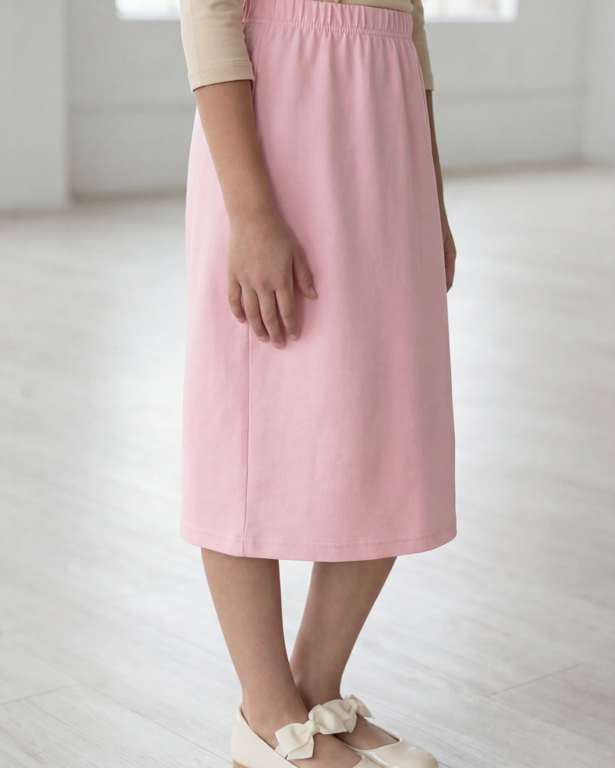 Model wearing the Nuggles® Girls' Classic Midi Skirt in Rose