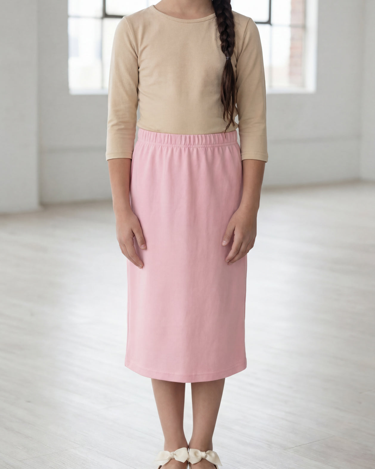Model wearing the Nuggles® Girls' Classic Midi Skirt in Rose