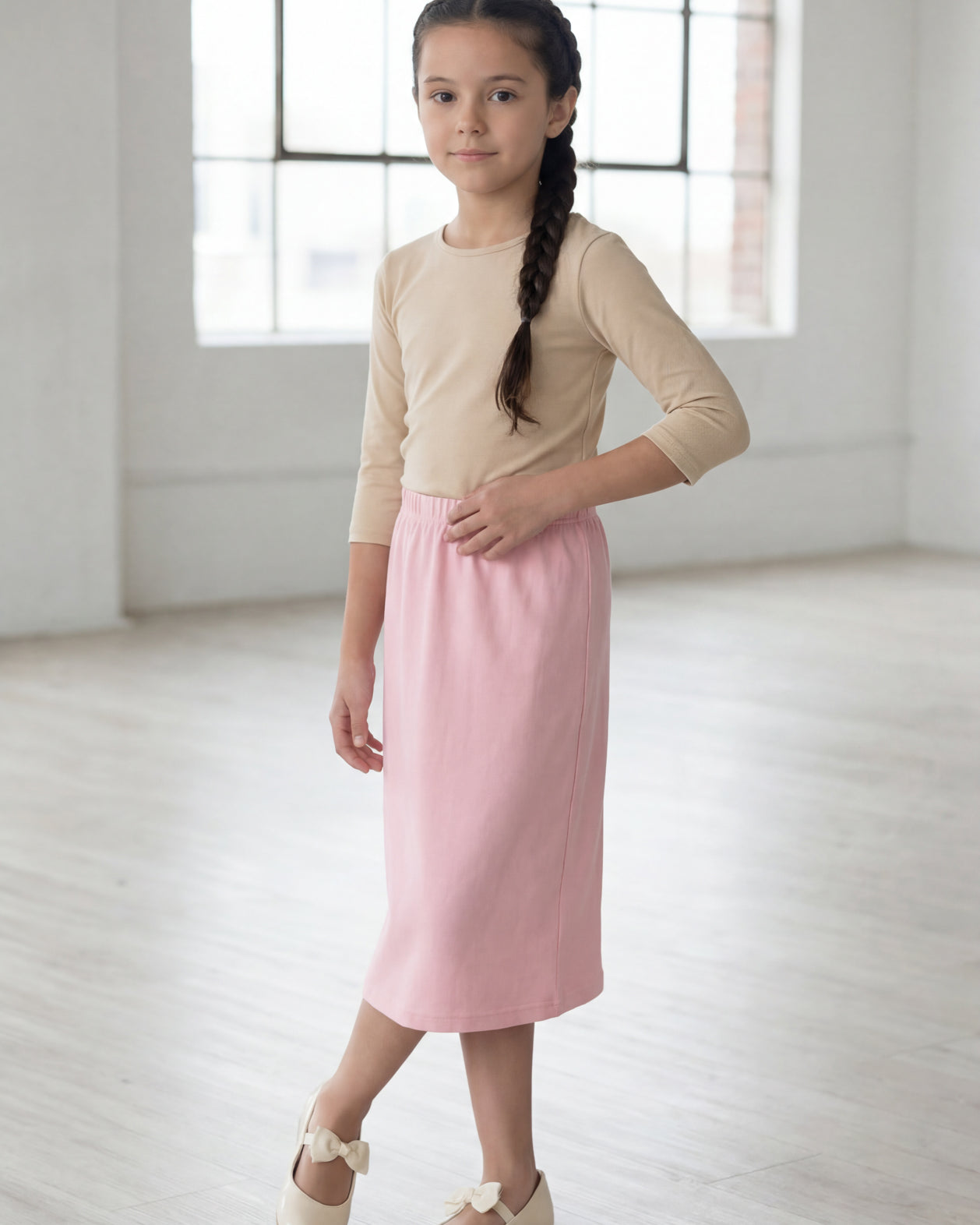 Model wearing the Nuggles® Girls' Classic Midi Skirt in Rose