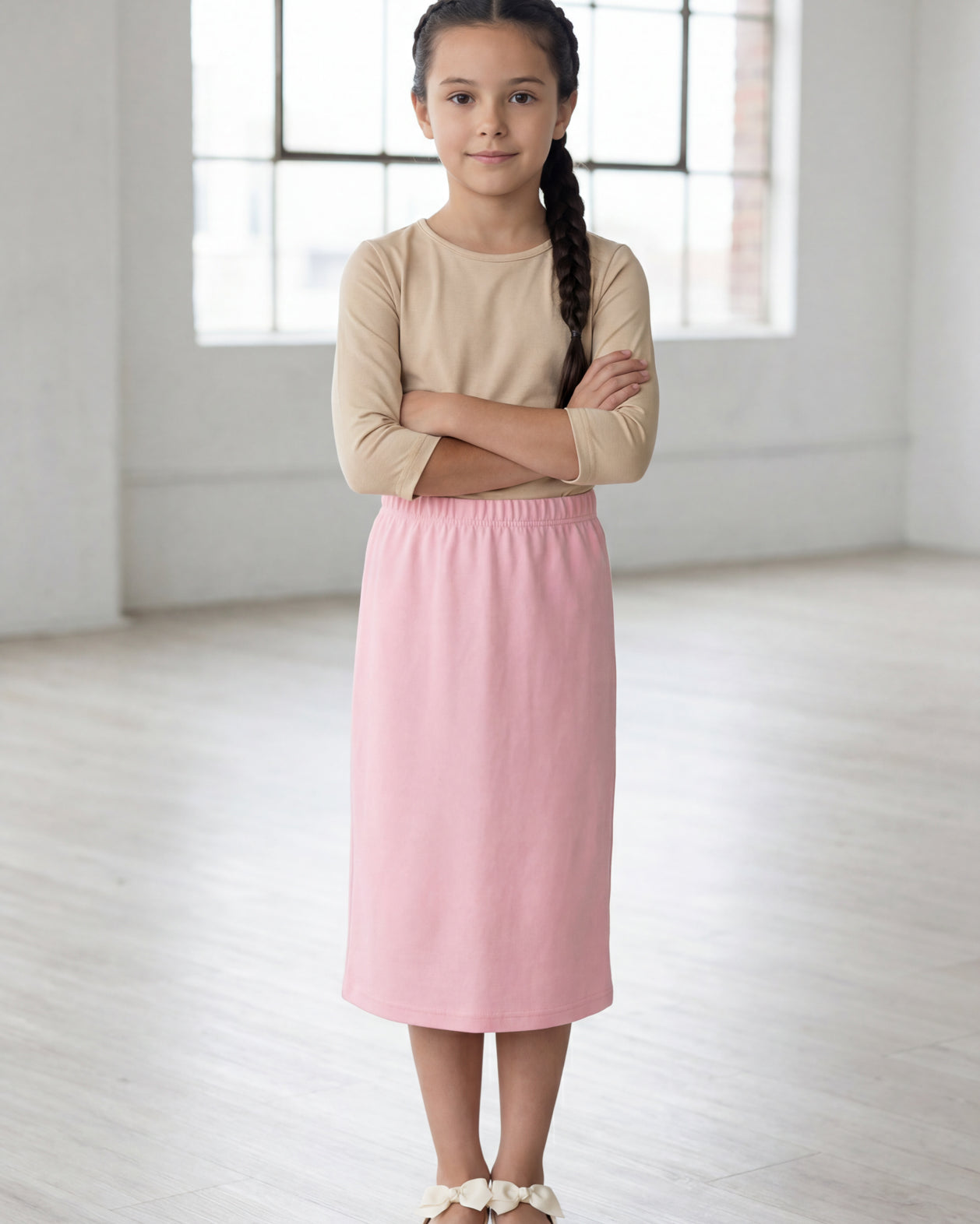 Model wearing the Nuggles® Girls' Classic Midi Skirt in Rose
