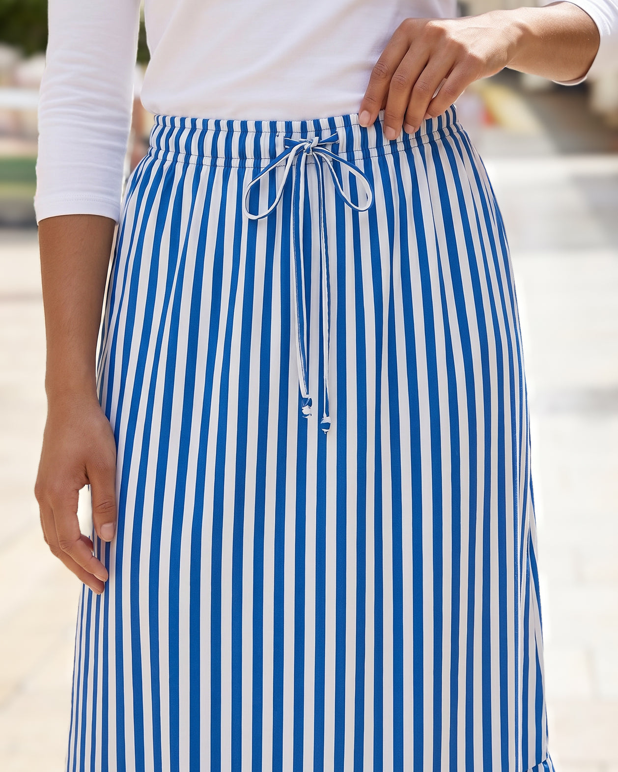A women wearing a veritcal blue and white striped maxi skirt.