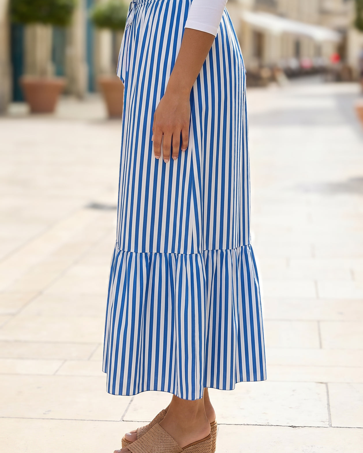 A women wearing a veritcal blue and white striped maxi skirt.