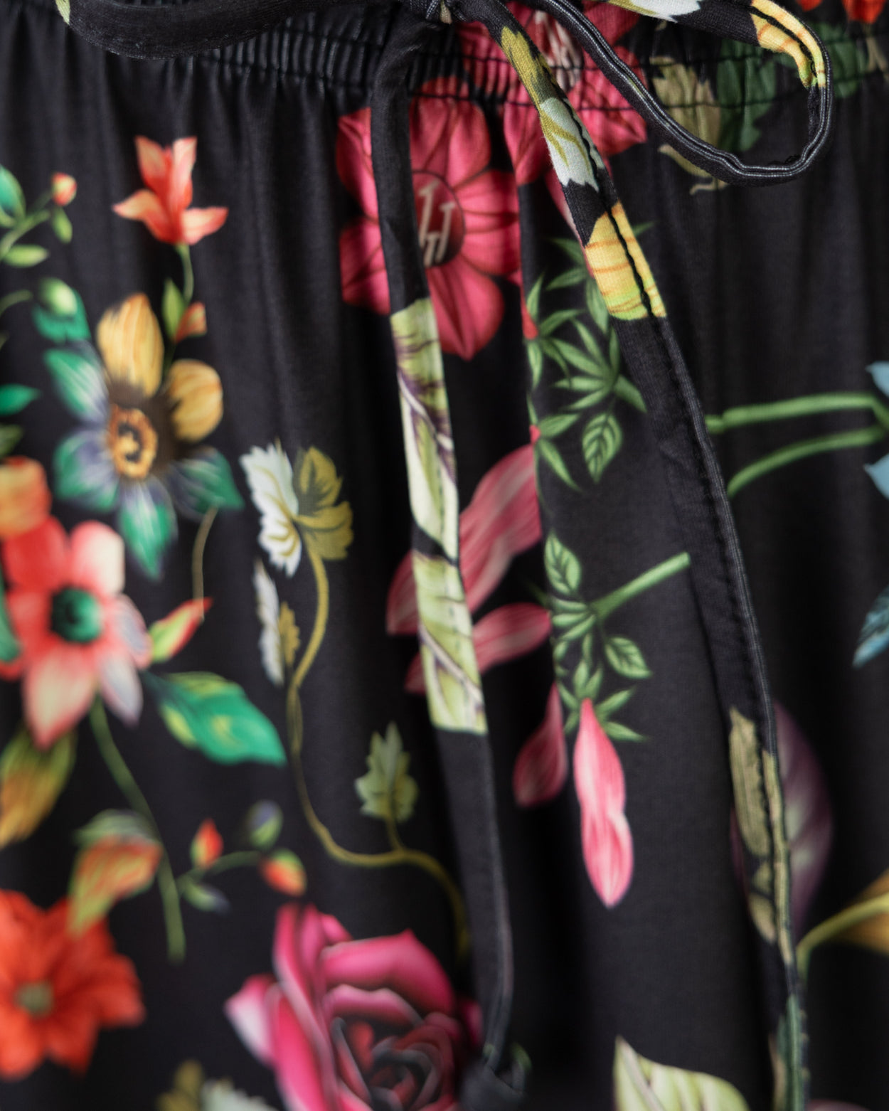 Floral-patterned fabric with a black drawstring on a dark background