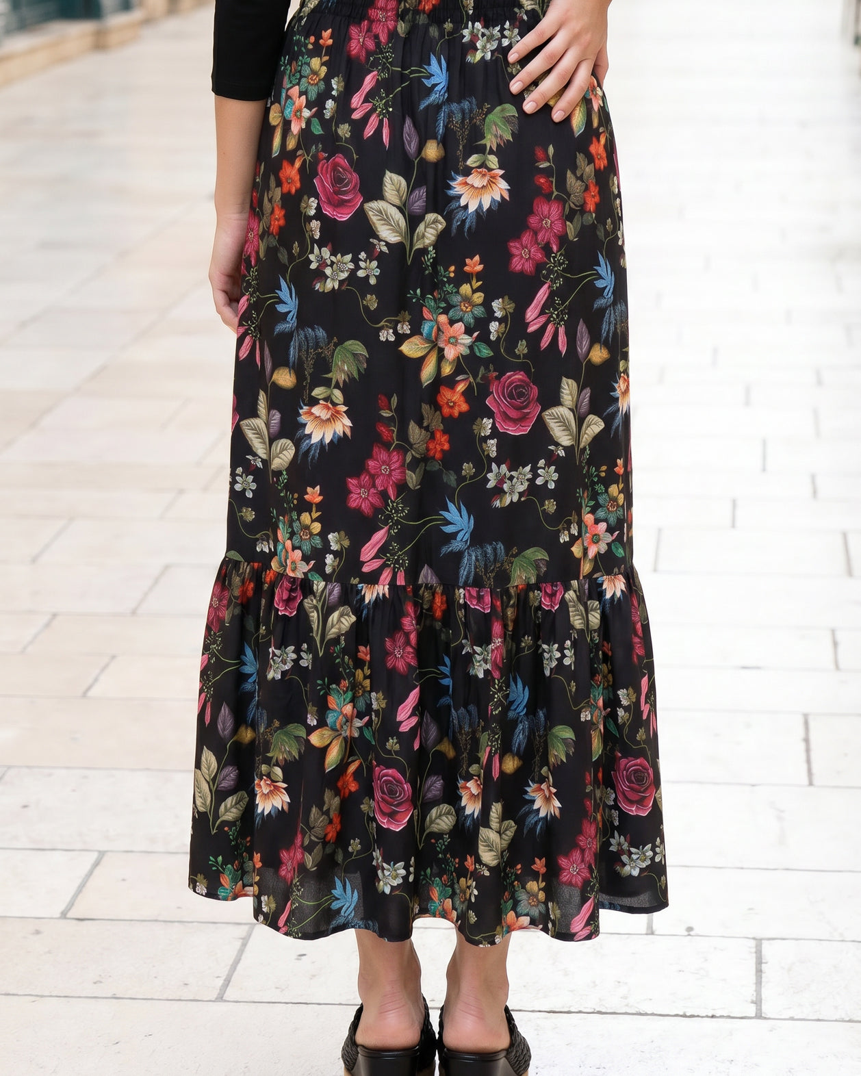 Person wearing a floral skirt with a white background