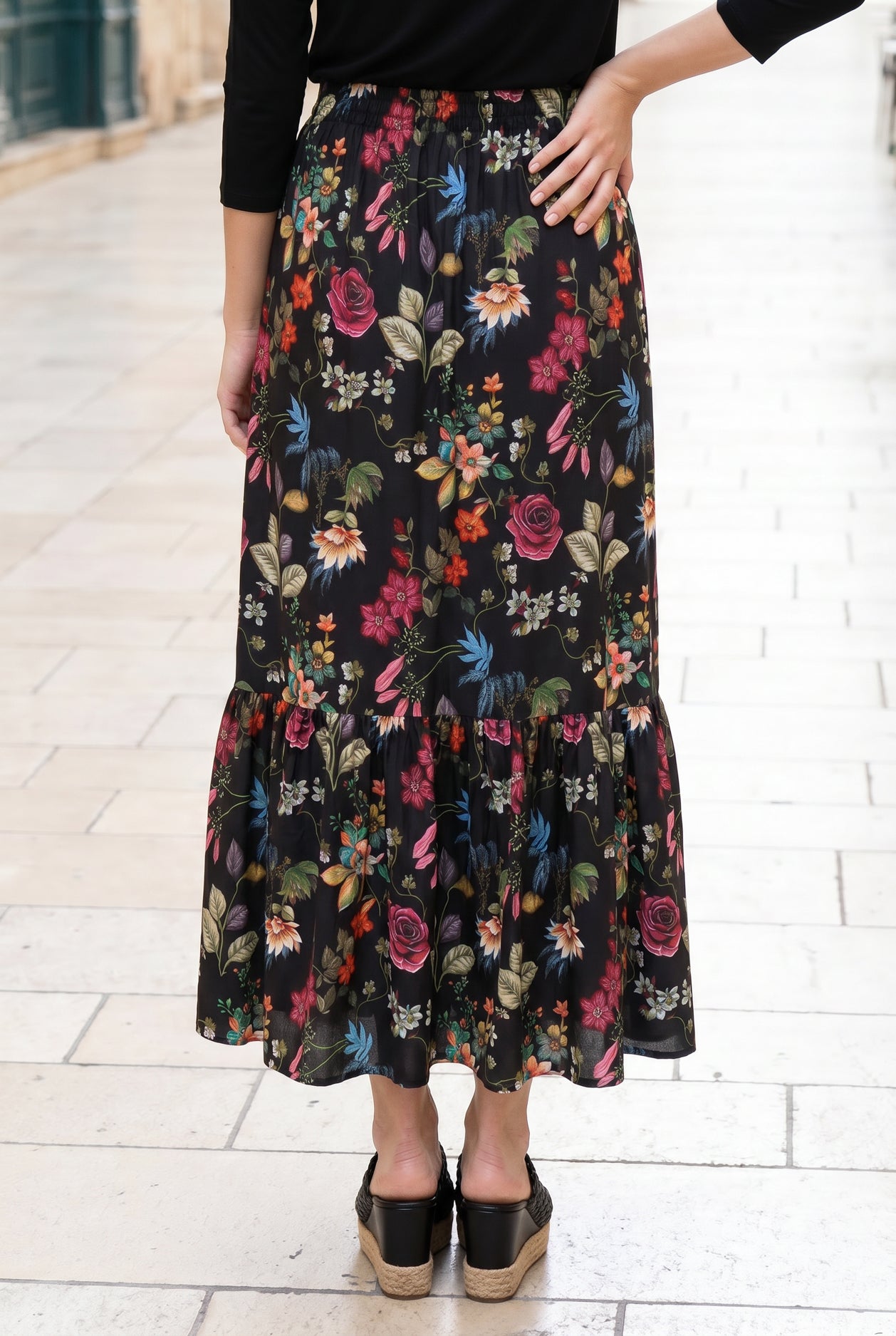 Person wearing a floral skirt with a white background