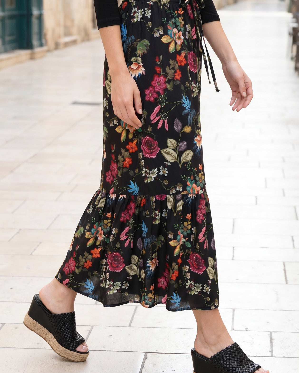 Person wearing a floral skirt on a city street