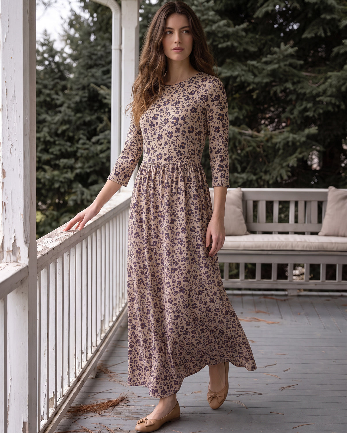 Nuggles® Cleo Maxi Dress in Tigerlily, full length mid-stride on a porch with one hand on the railing