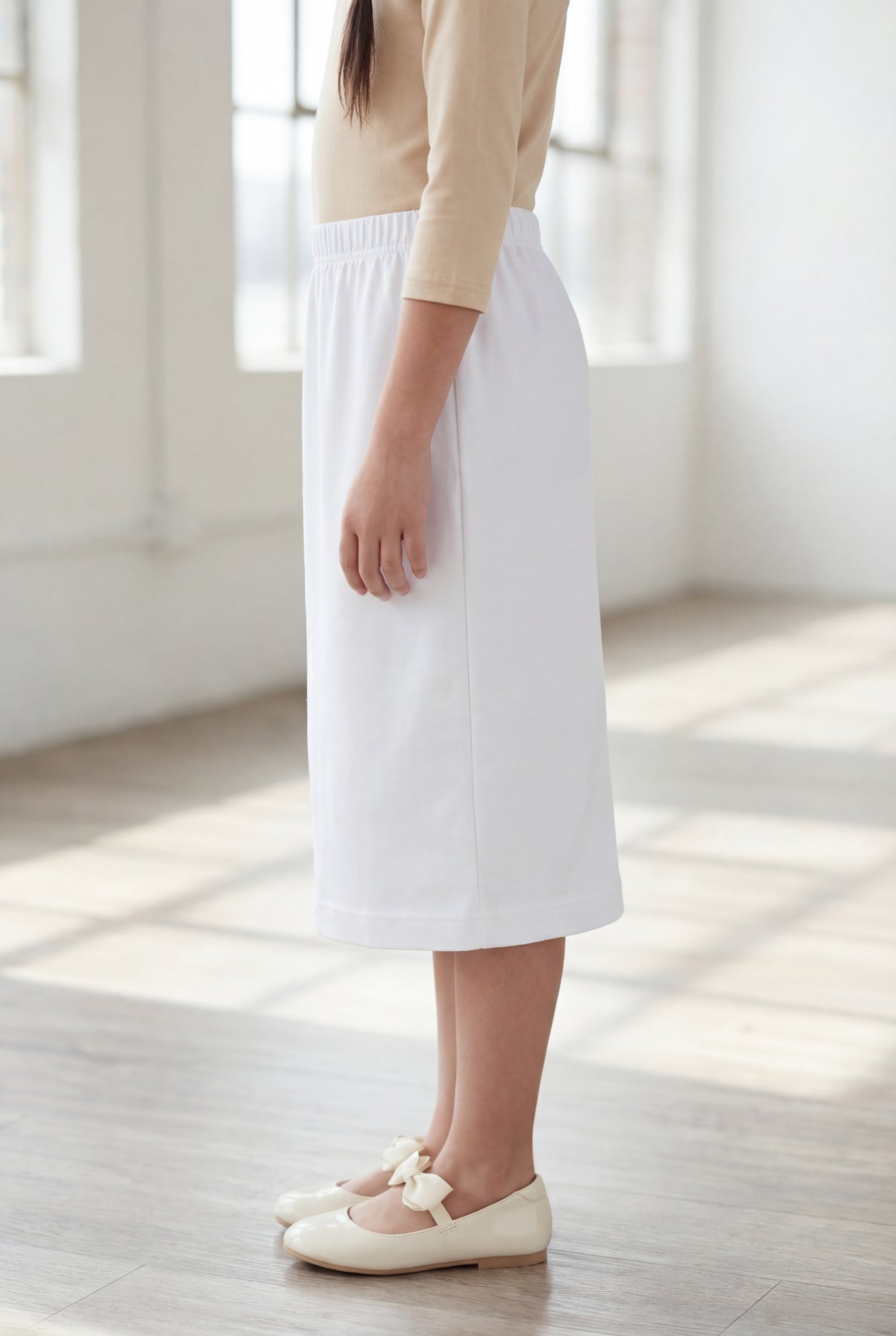 Model wearing Nuggles® Girls Classic Skirt in White