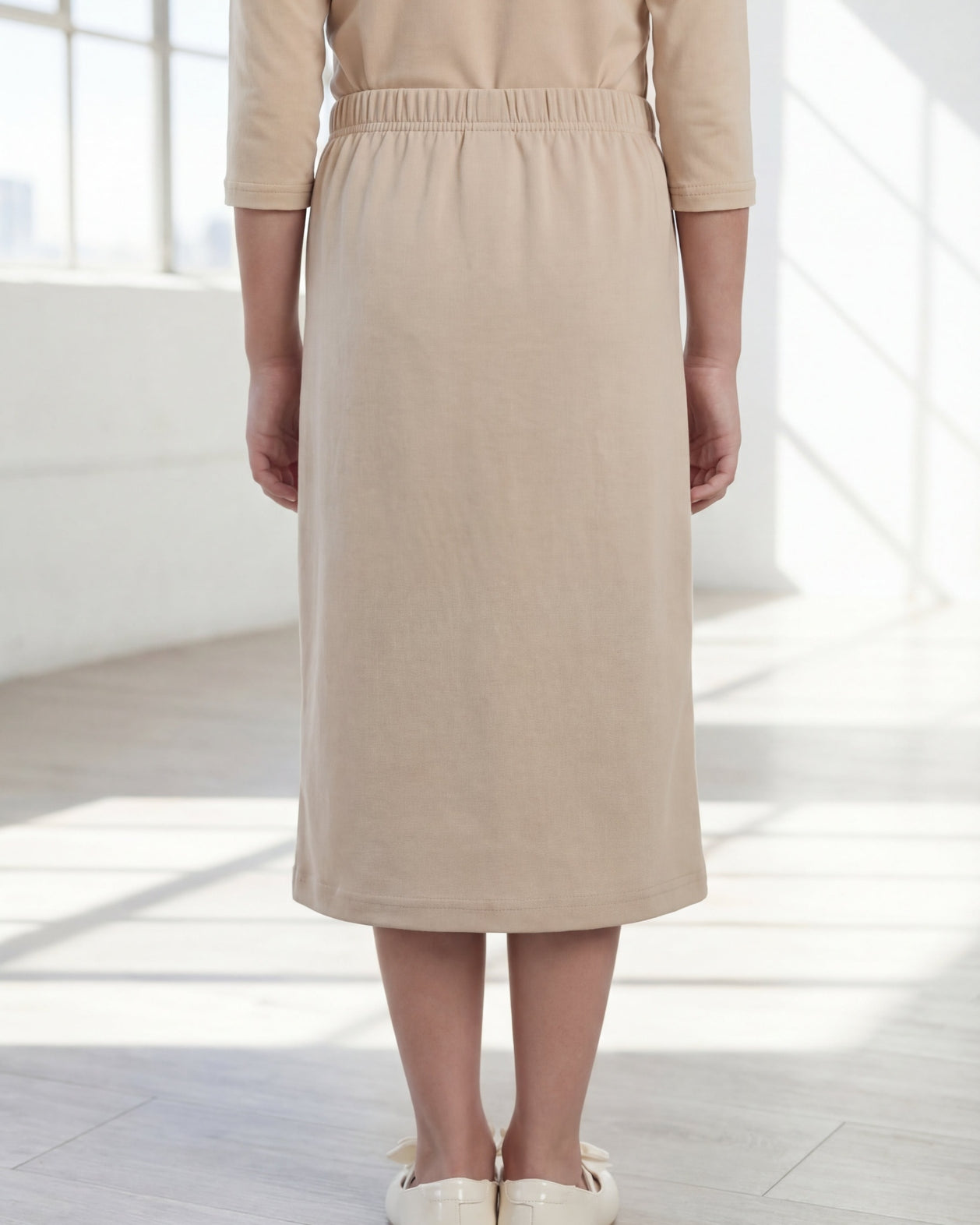 Model wearing the Nuggles® Girls' Classic Midi Skirt in Khaki