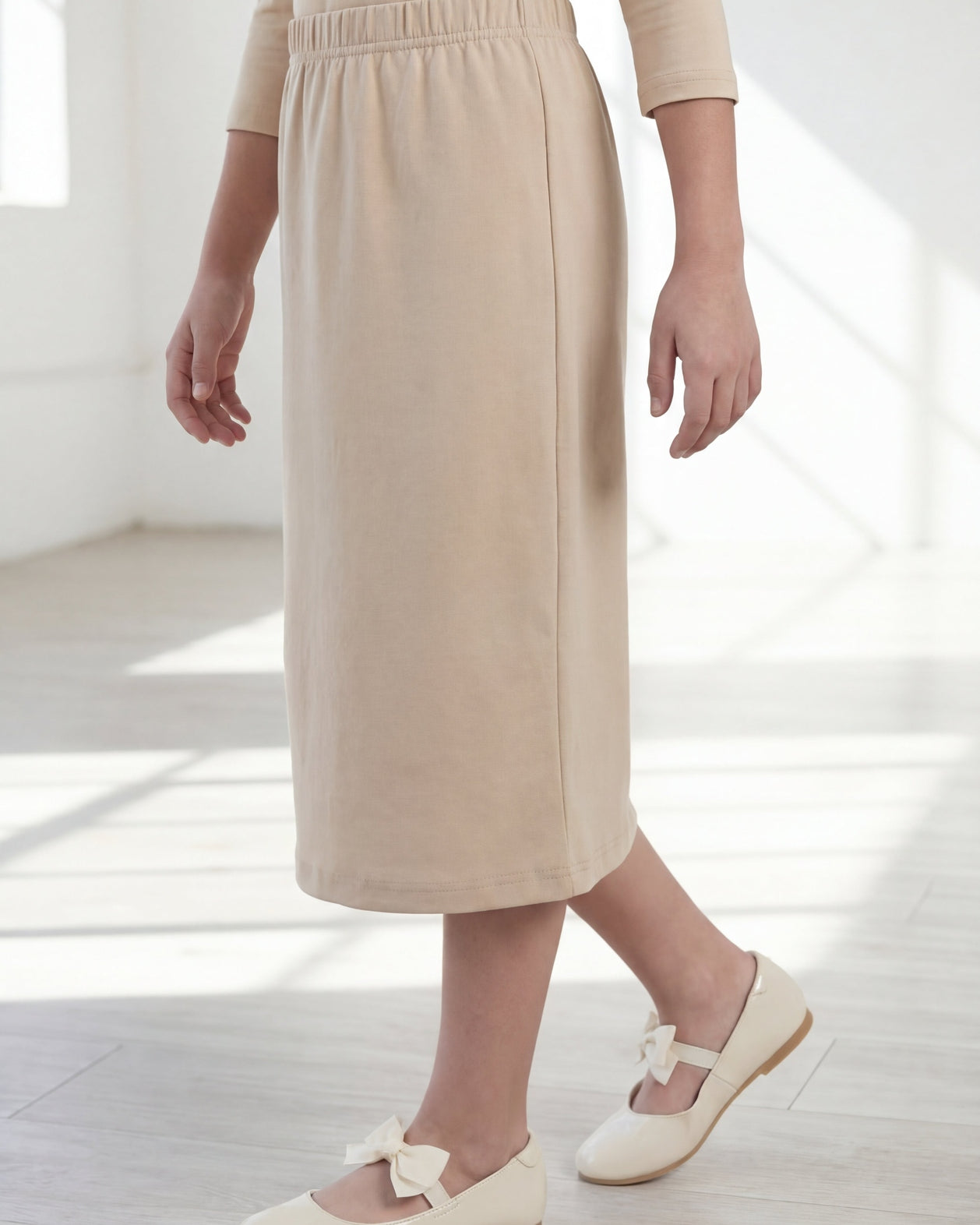 Model wearing the Nuggles® Girls' Classic Midi Skirt in Khaki
