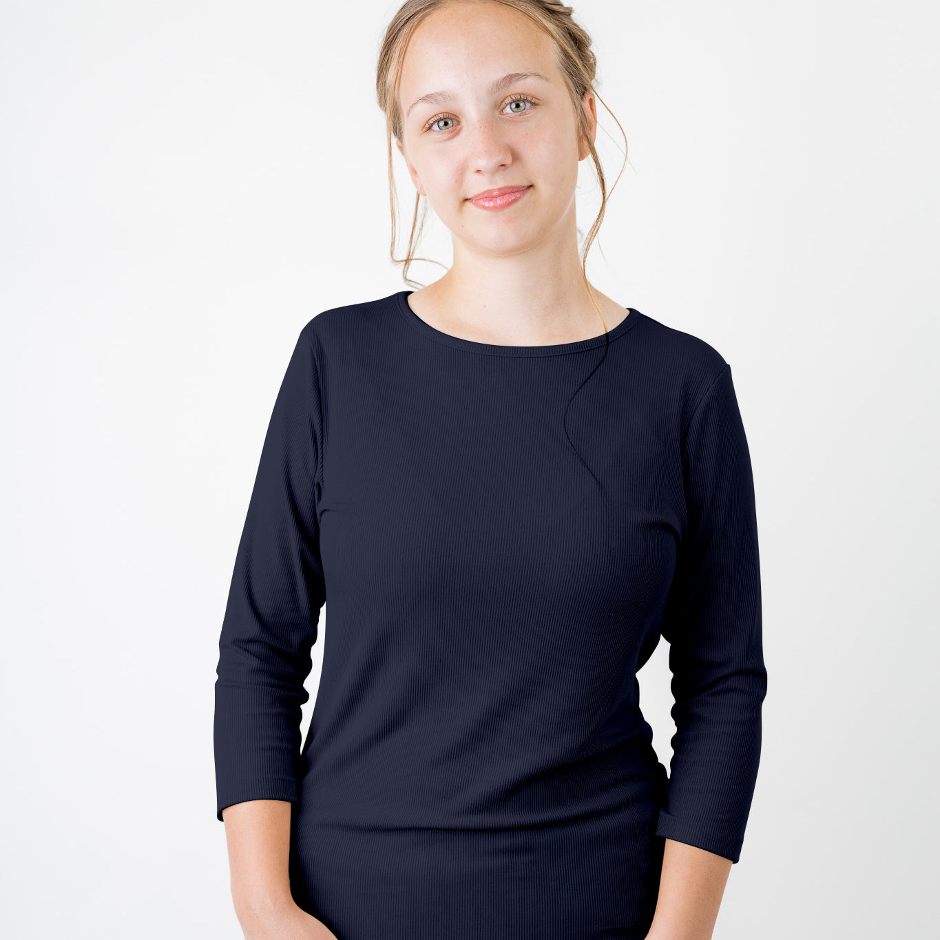 Model wearing the  Nuggles®  Essential 3/4 Tee in ribbed fabric, a modest, fitted top with 3/4 sleeves and a rounded neckline. Shown in a neutral tone, ideal for layering.