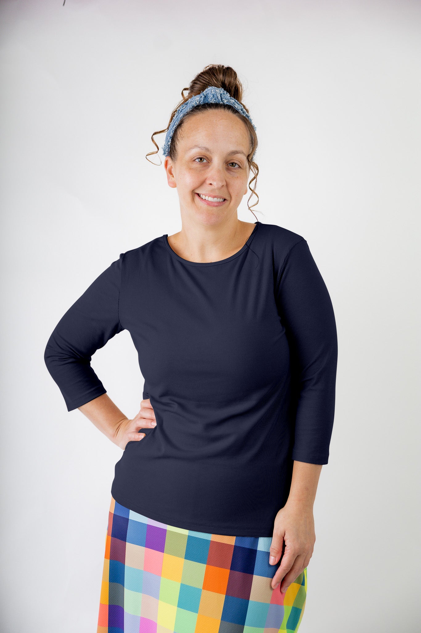 Model wearing the  Nuggles®  Essential 3/4 Tee in ribbed fabric, a modest, fitted top with 3/4 sleeves and a rounded neckline. Shown in a neutral tone, ideal for layering.