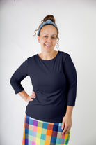 Model wearing the  Nuggles®  Essential 3/4 Tee in ribbed fabric, a modest, fitted top with 3/4 sleeves and a rounded neckline. Shown in a neutral tone, ideal for layering.