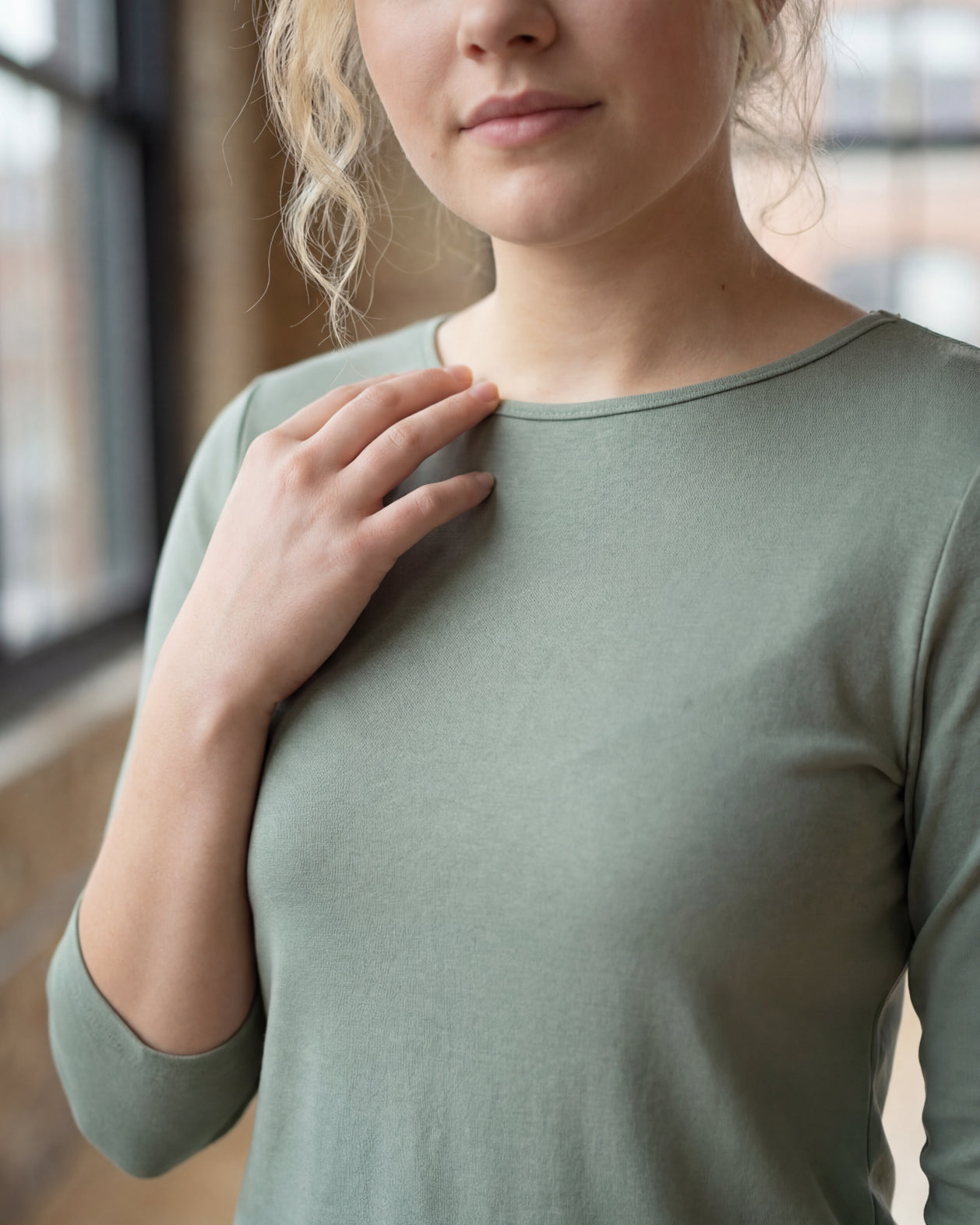 Model wearing the Nuggles® Essential 3/4 Tee in seafoam green