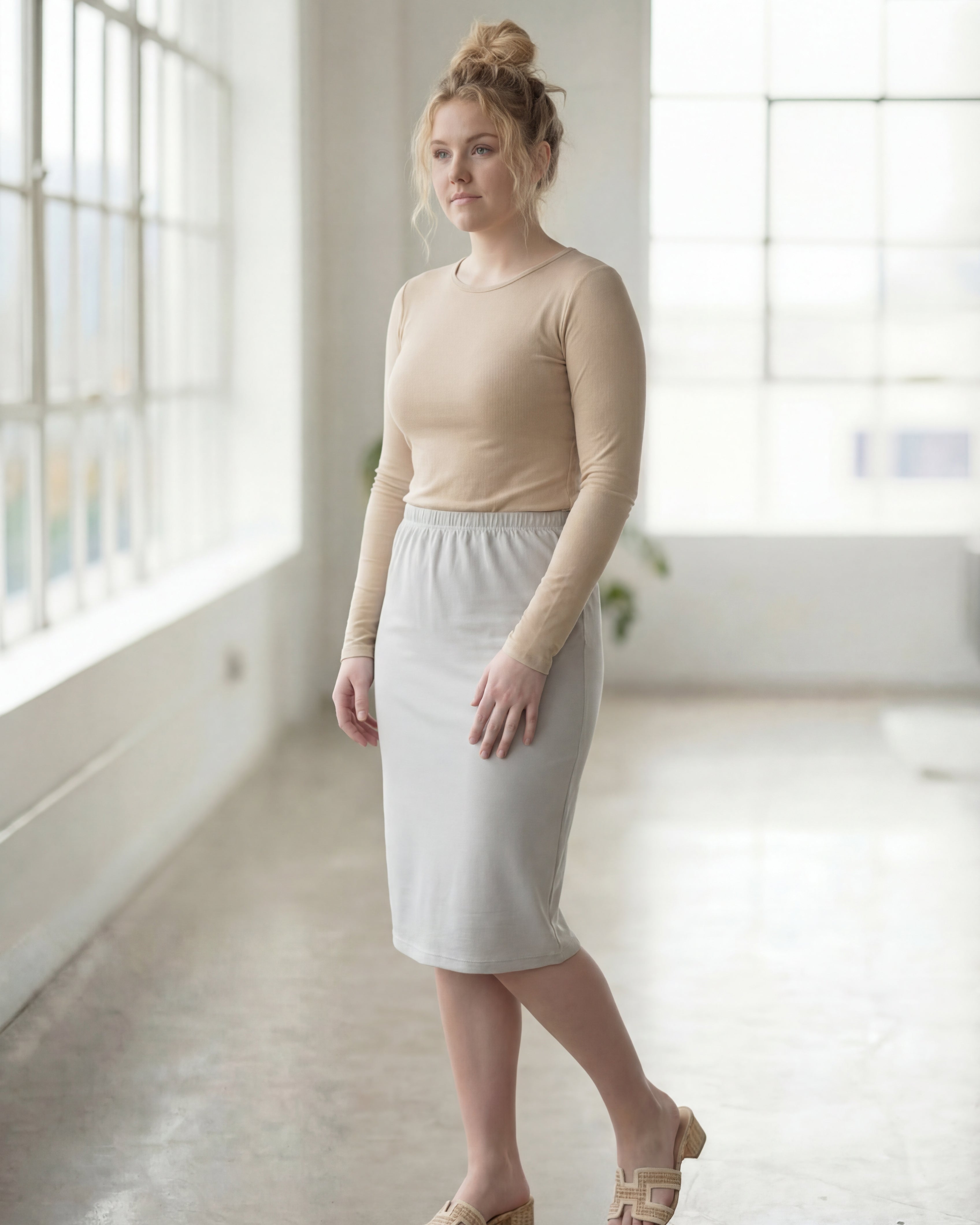 Women wearing a silver classic 27" midi length skirt with a beige shirt in a sunlight loft.