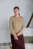 Model styling a neutral Nuggles® long sleeve top for casual everyday outfit inspiration.