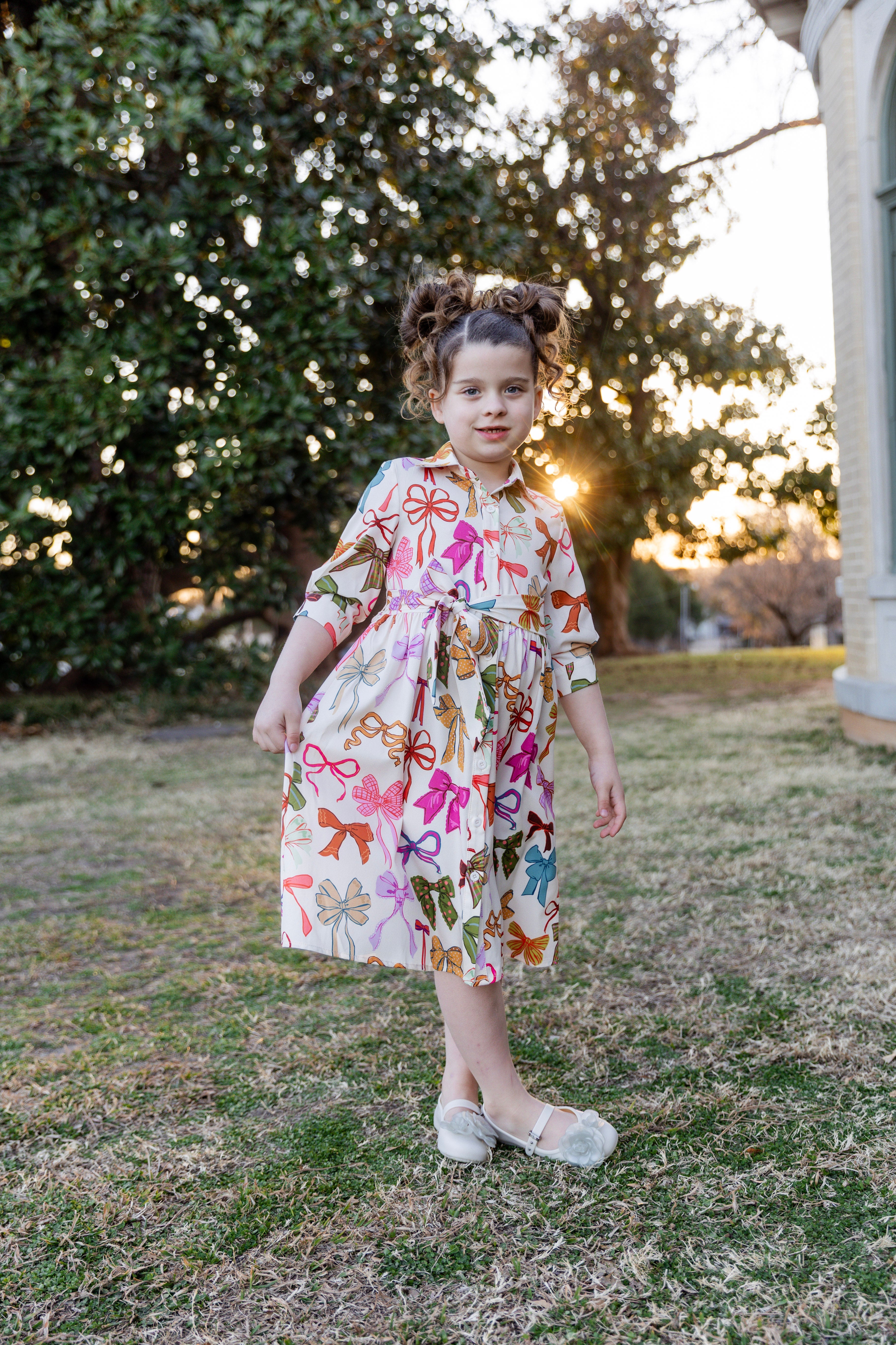 Modest Girls Clothing for sizes 4T to girls size 14. This is a model wearing Nuggles® Raegan Dress in Bow Belle.