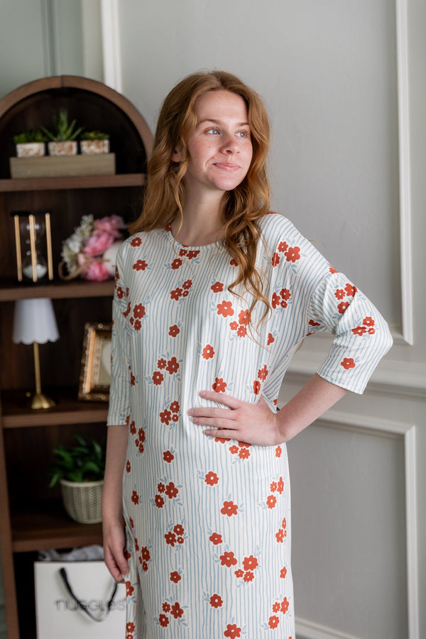 A model wearing a midi length dress with 3/4 length sleeves. 