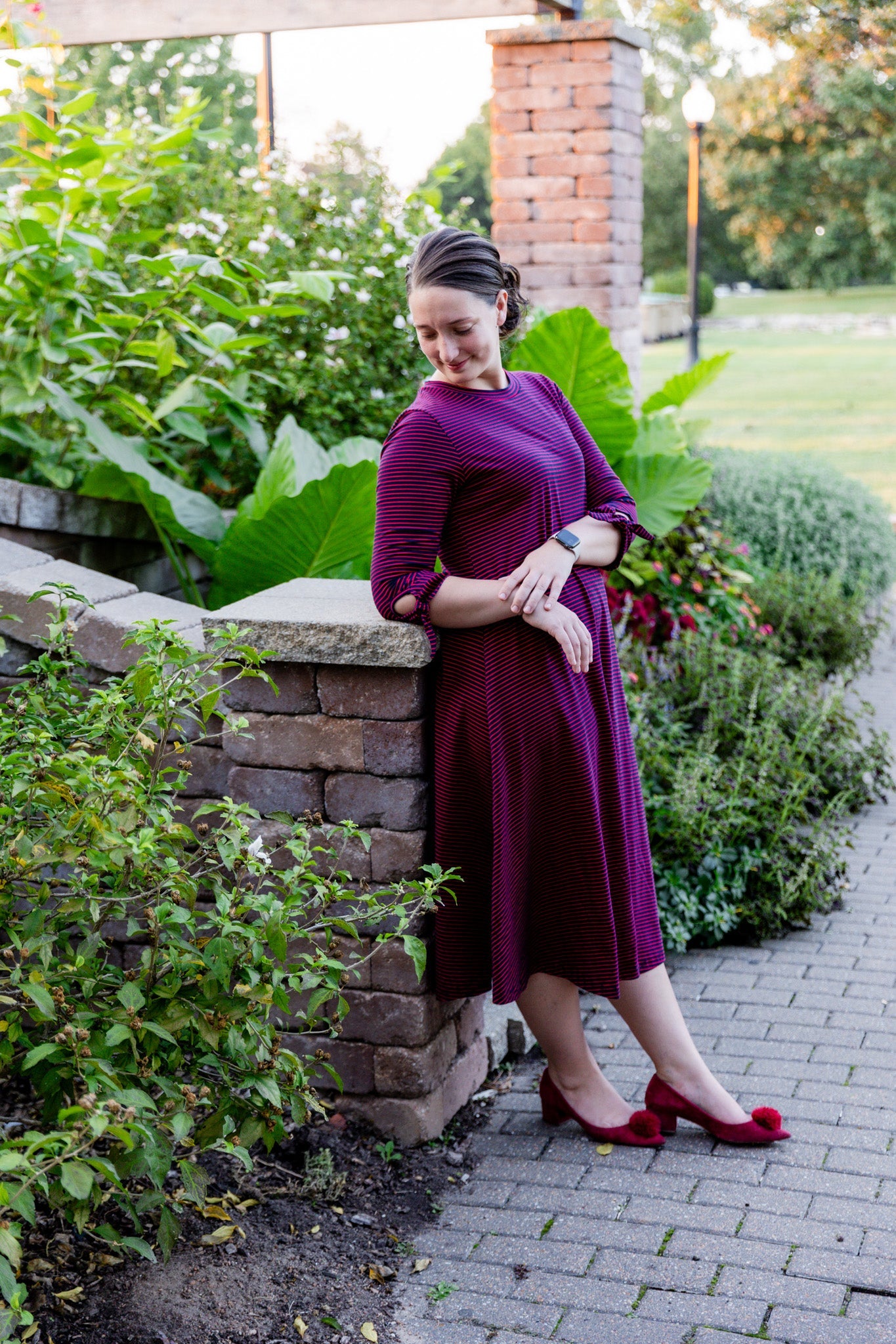 Women wearing a modest, midi length dress with 3/4 length sleeves in a black and white vertical stripe dress.