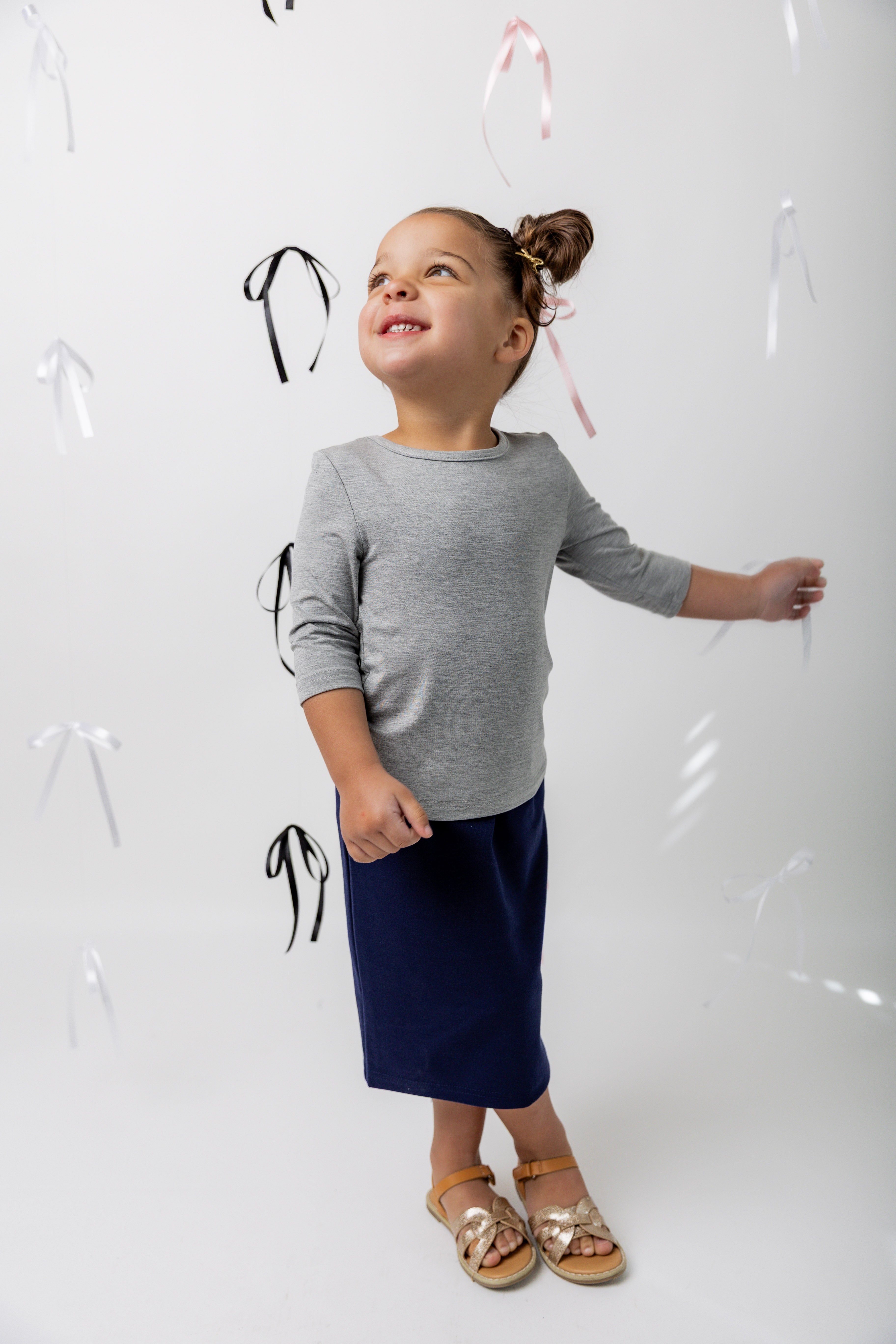 Girl wearing a gray modest essential t-shirt with a midi length, modest classic skirt.