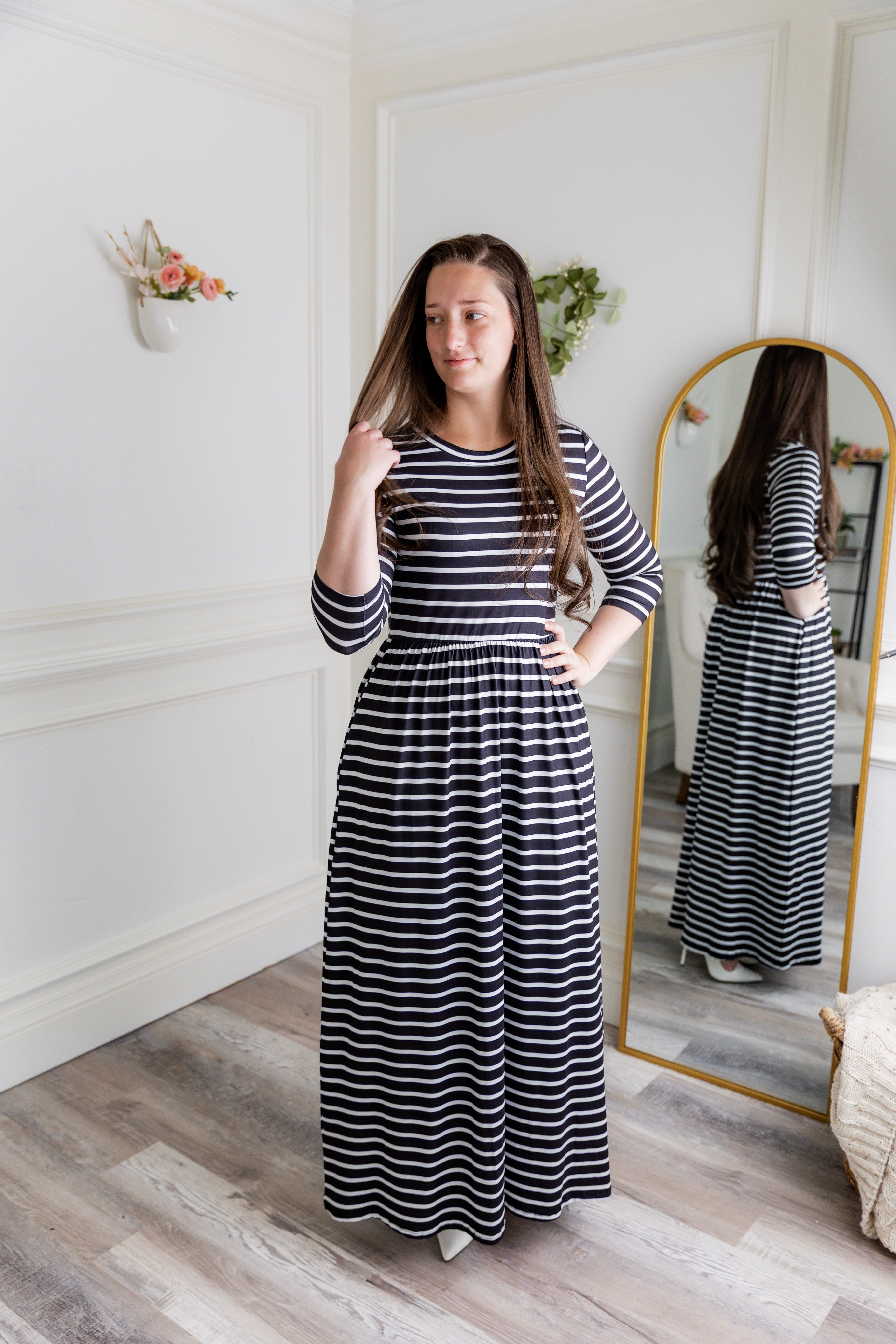 Women wearing a horizontal black and white stripe dress in a modest, maxi length.