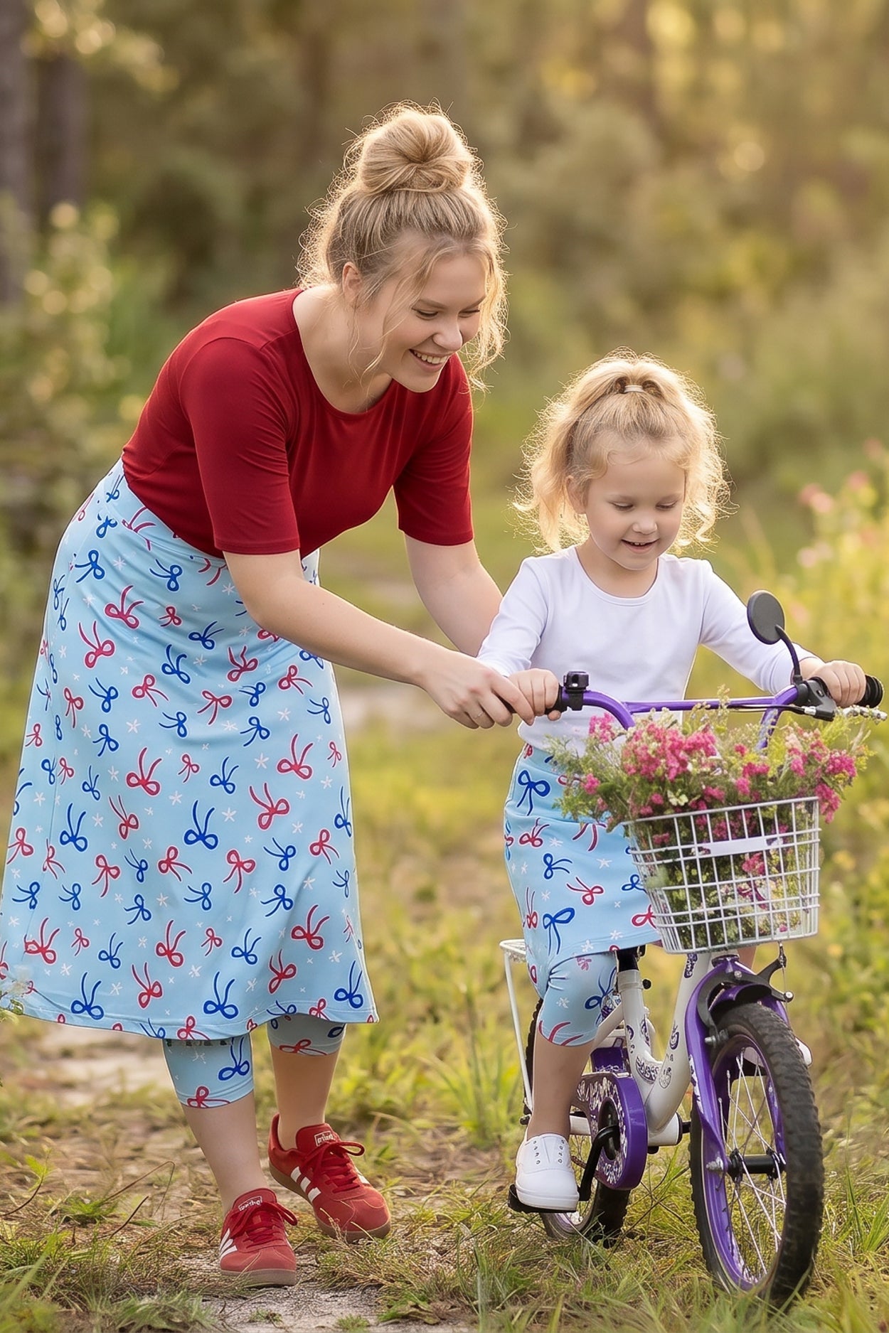 A picture of a women and girl in modest sport skirts with the girl riding a bike.